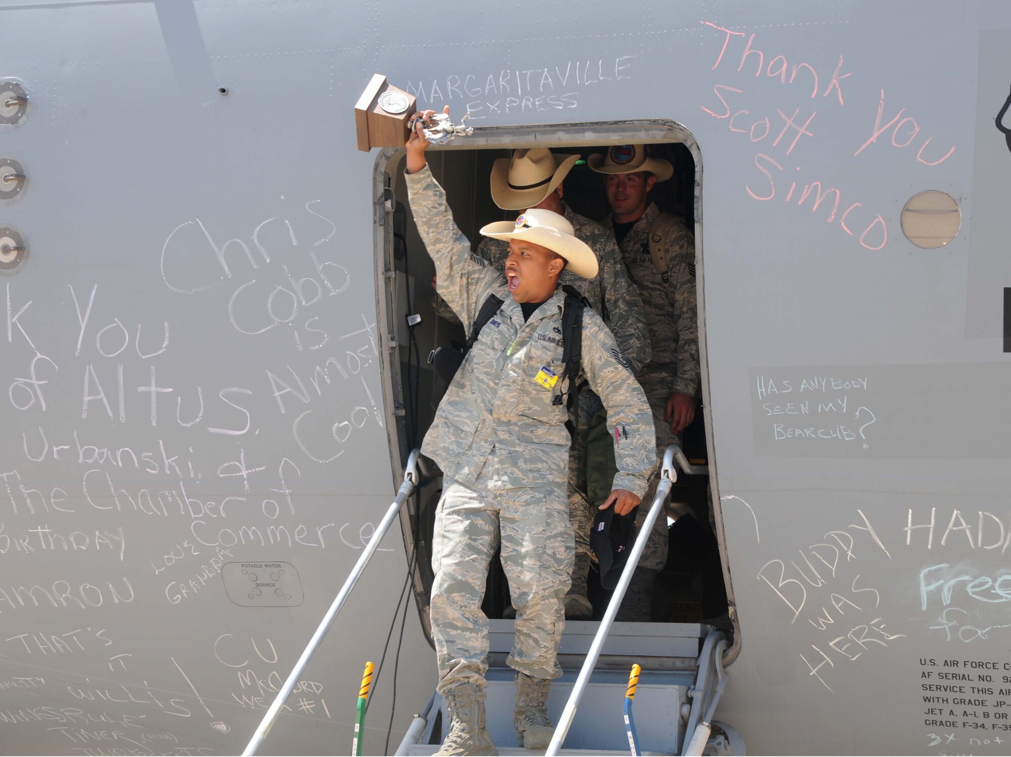 ALTUS AIR FORCE BASE, Okla. -- Tech. Sgt. Nolan Jones, 97th Logistics Readiness Squadron team leader, holds up a trophy as he exits a C-17 Globemaster III July 25. The LRS Team won Best C-17 Engine Running Off Load Team during the 2009 Air Mobility RODEO at McMchord Air Force Base. (U.S. Air Force photo by Senior Airman Cherice Bryant)
