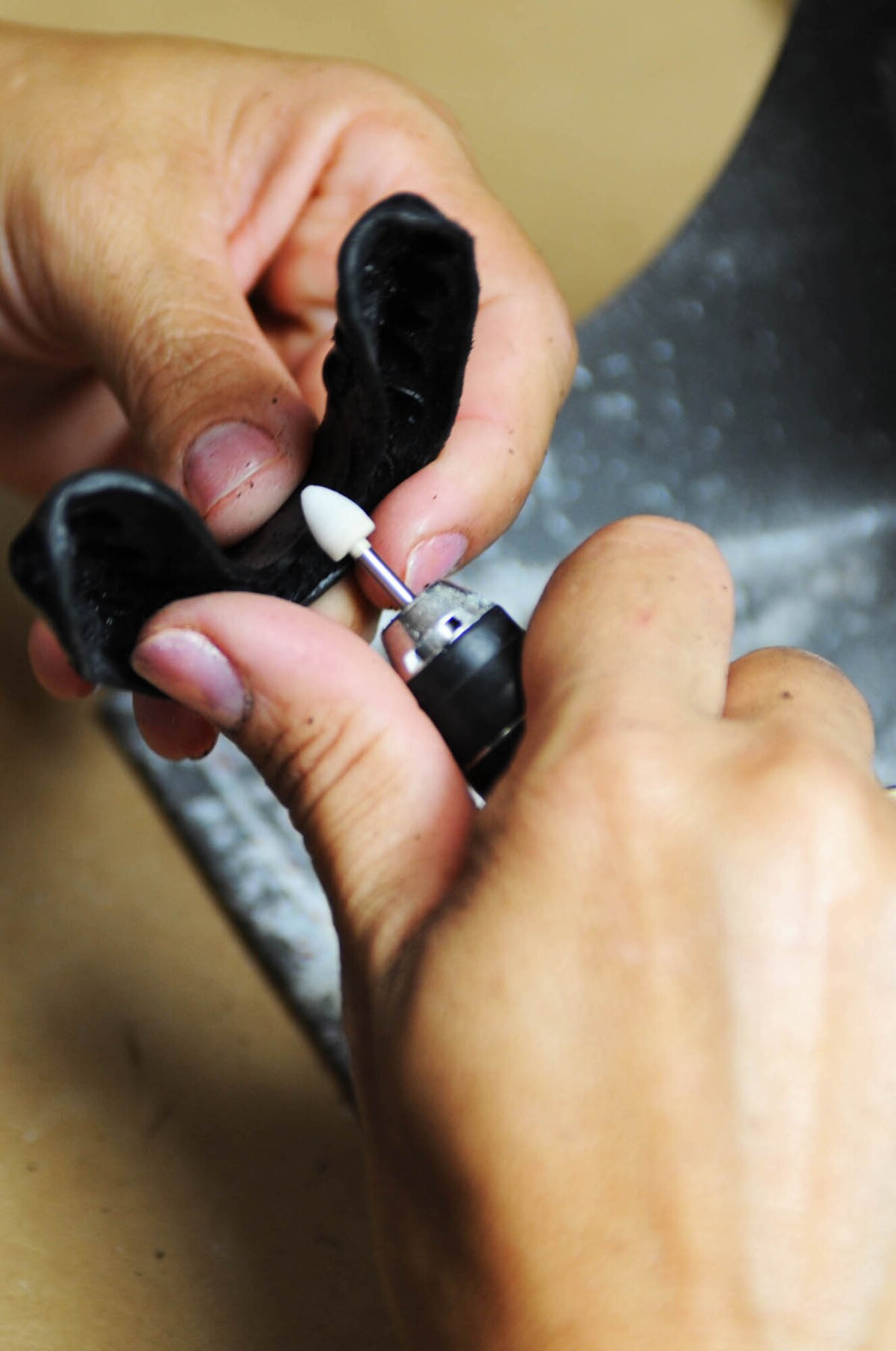 Master Sgt. Andrea Bates, 28th Medical Group NCO-in-charge of dental laboratory, smoothes edges around a mouthpiece here, July 30. The mouthpiece is used to absorb shock and protect teeth during extracurricular activities. (U.S. Air Force photo/Airman 1st Class Adam Grant)