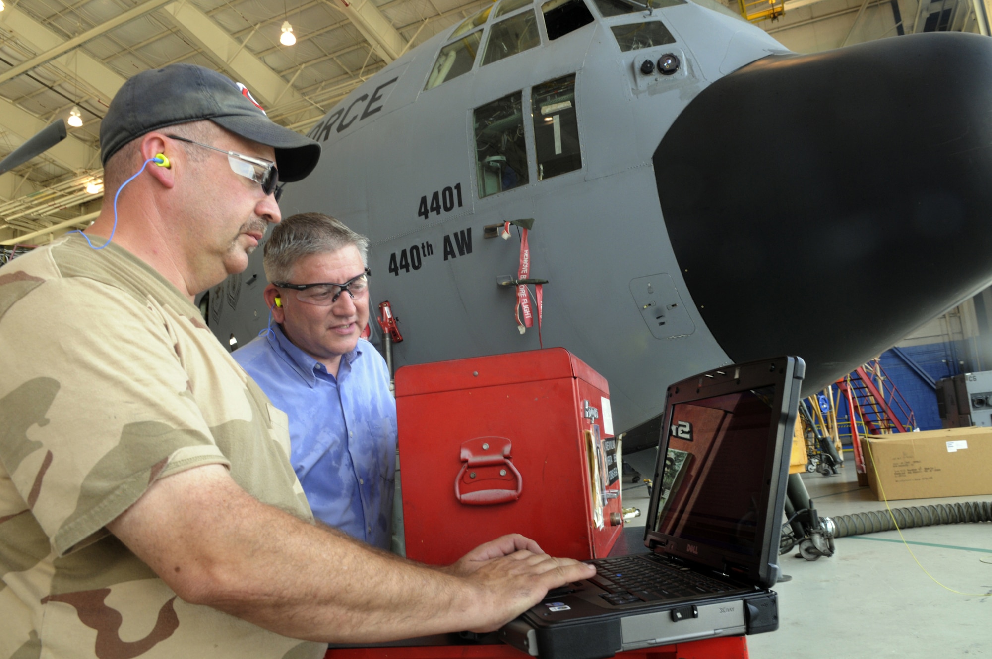 Jim Meyer, aircraft mechanic, and Tim Reynolds, technical project lead for e-tools deployment, look at and talk about the new e-tool. U. S. Air Force photo by Sue Sapp