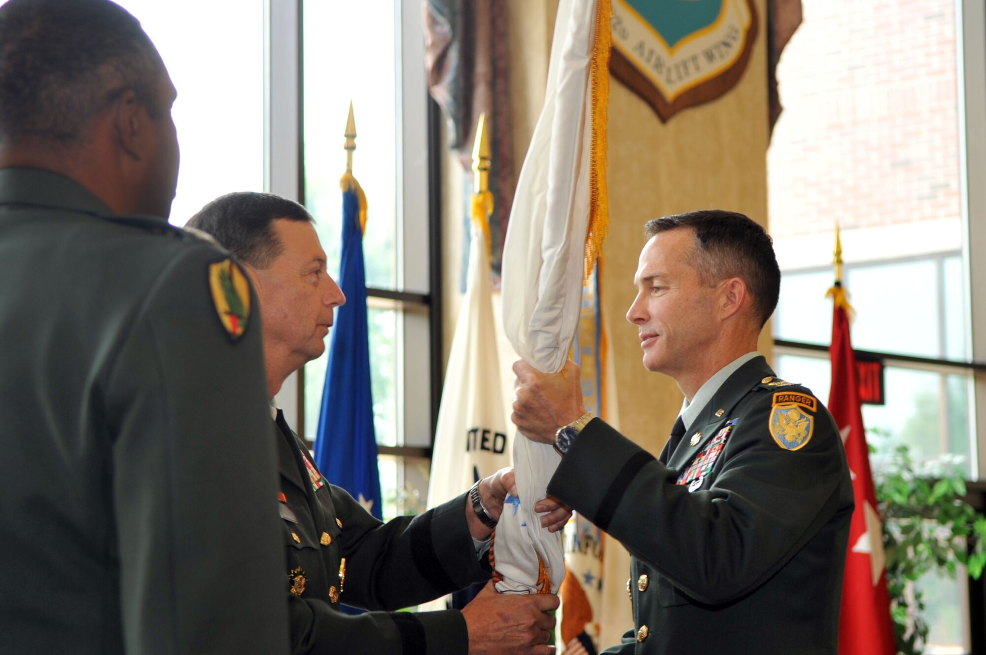 SCOTT AIR FORCE BASE, Ill -- Army Lt. Gen. Carroll Pollett passes the guidon of the Defense Information Systems Agency to Army Col. Randy Taylor during the change of command ceremony at  the Scott Club July 30.  Colonel Taylor assumed command from Army Col. Cyrus Gwyn. (U.S. Air Force photo/ Senior Airman Teresa Hawkins)