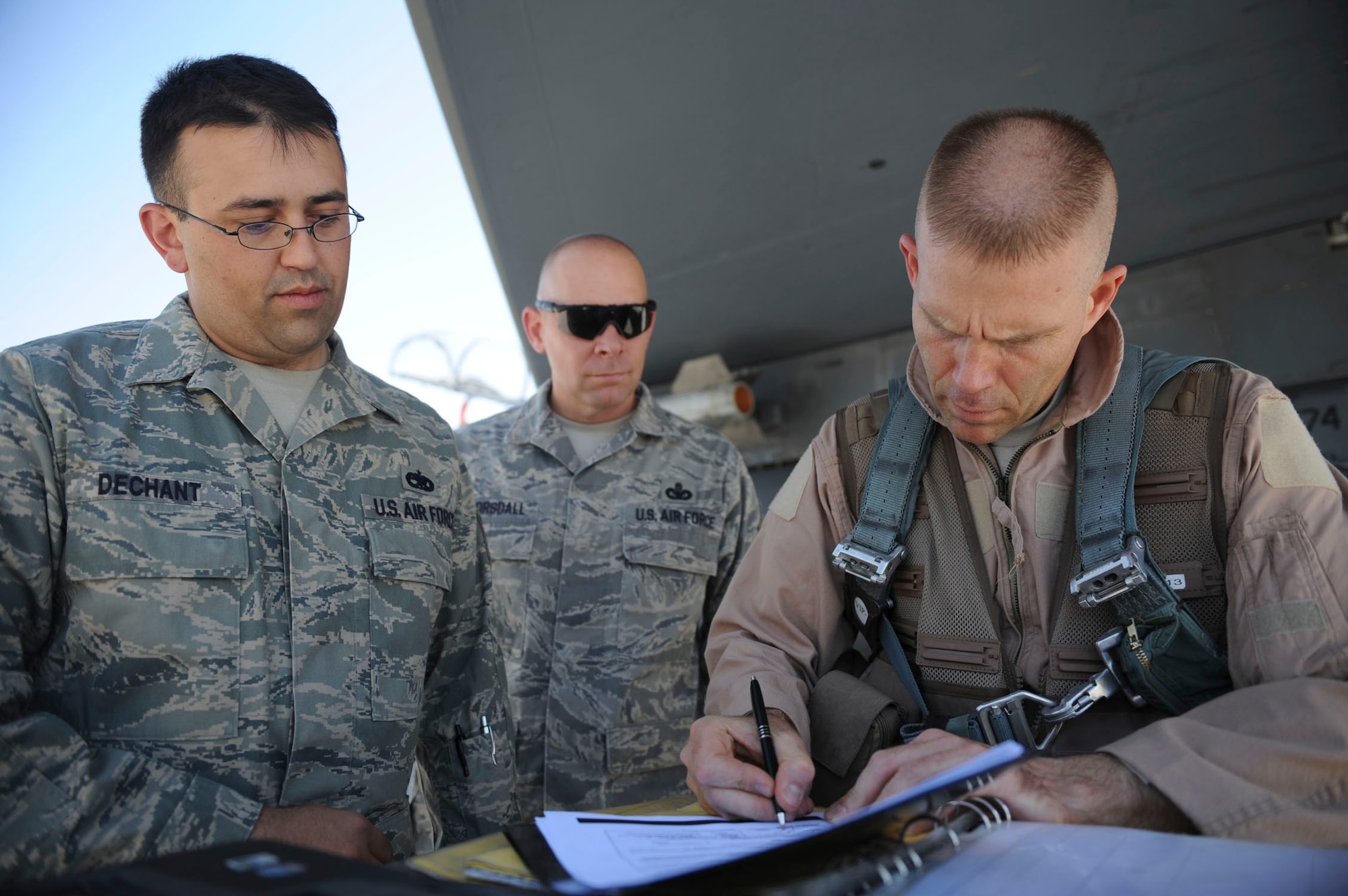 BAGRAM AIRFIELD, Afghanistan - Tech. Sgt. Lucas Dechant, a 12-year Air Force veteran, gets reenlisted under the wing of an F-15E Strike Eagle. The 455th Air Expeditionary Wing commander, Brig. Gen. Steven L. Kwast, signed his reenlistment paperwork and also presided over the ceremony where friends and coworkers from the maintenance squadron gathered. A Denver native, Sergeant Dechant is on his fourth deployment. He is stationed at Seymour Johnson Air Force Base, N.C. (U.S. Air Force photo/Staff Sgt. J.G. Buzanowski)