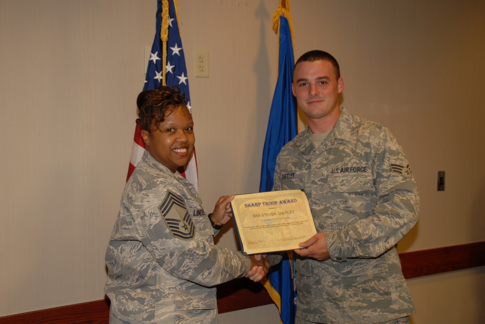 Chief Master Sgt. Bionca Lindsey (left), 19th Medical Group superintendent, presents Senior Airman Steven Sheeley, 314th Maintenance Squadron crew chief, the Chief’s Sharp Troop award July 21 at the Hercules Dining Facility. Airman Sheeley played a key role in rescuing a couple from a crashed car, streamlined the Composite Tool Kit process for his work center and corrected approximately 160 discrepancies discovered during weekly tool box inspections resulting in zero defects on five quality assurance evaluations. (U.S. Air Force photo by Staff Sgt. Nestor Cruz)
