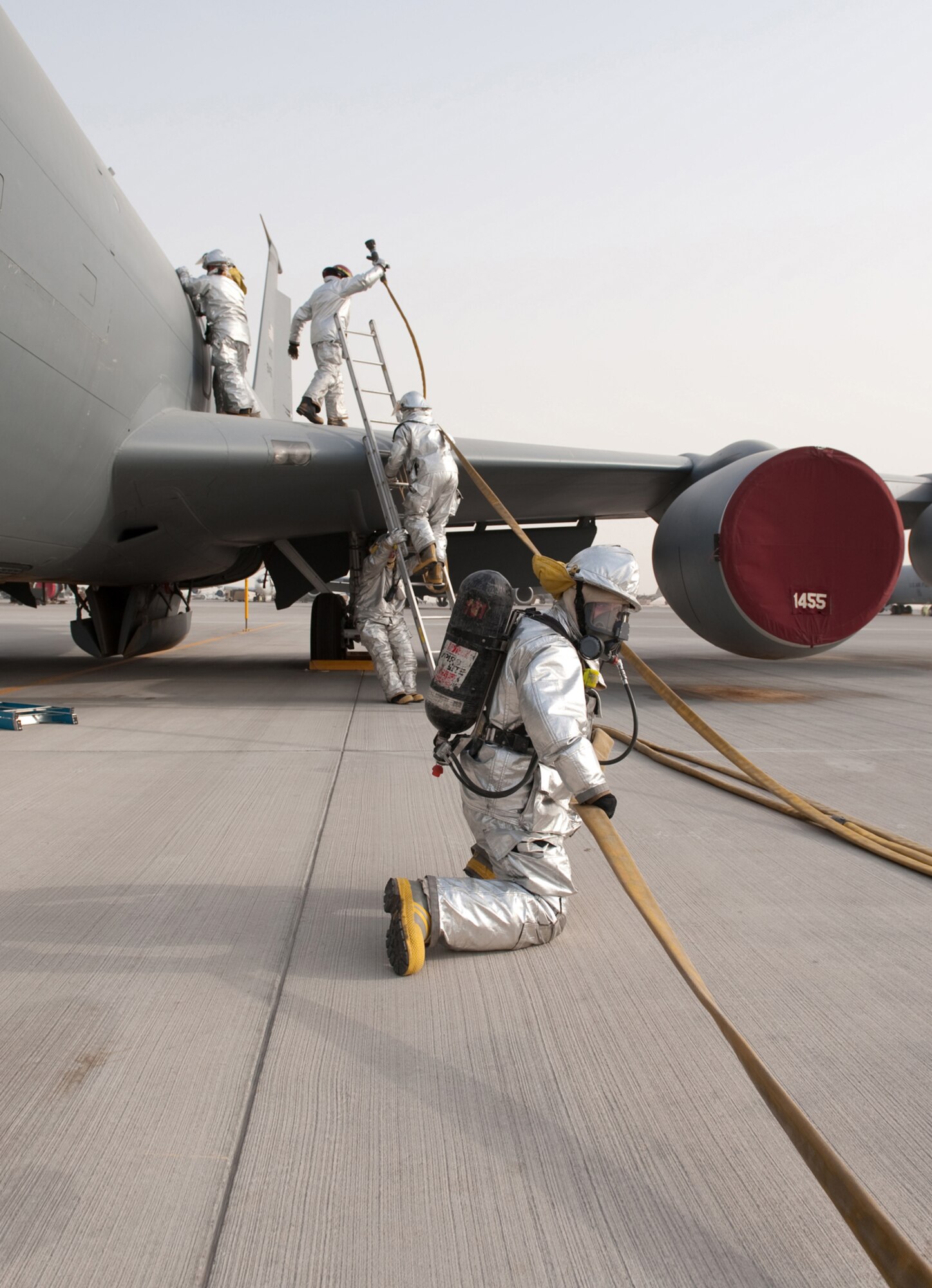 Firefighters from the 379th Expeditionary Civil Engineer Squadron conduct egress training on a simulated KC-135 engine fire, Aug. 5, in Southwest Asia. The 379 ECES firefighters respond to a wide range of emergencies and must maintain proficient on all emergency response procedures. All of the firefighters are deployed to Southwest Asia in support of Operations Iraqi and Enduring Freedom. (U.S. Air Force Photo/Staff Sgt. Robert Barney)