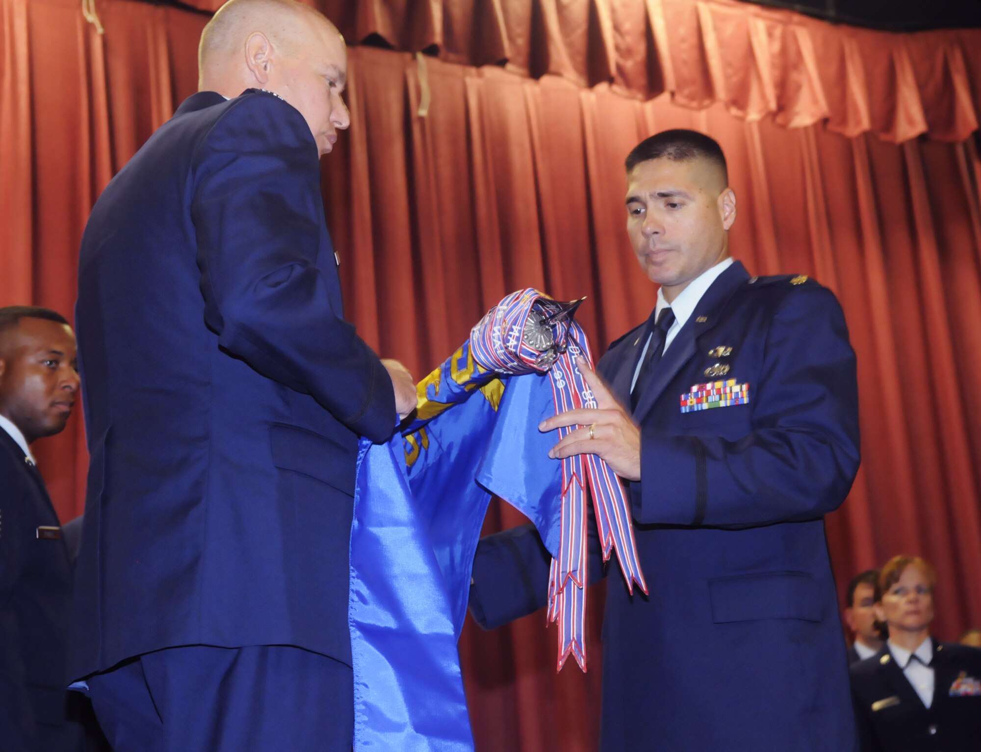 Col. John M. Bukowinski (left), 402nd Aircraft Maintenance Group commander, and Maj. Joseph Giuliani, 653rd Combat Logistics Support Squadron commander, furl the 653rd guidon at the inactivation ceremony for the squadron August 5. (U. S. Air Force photo by Sue Sapp)