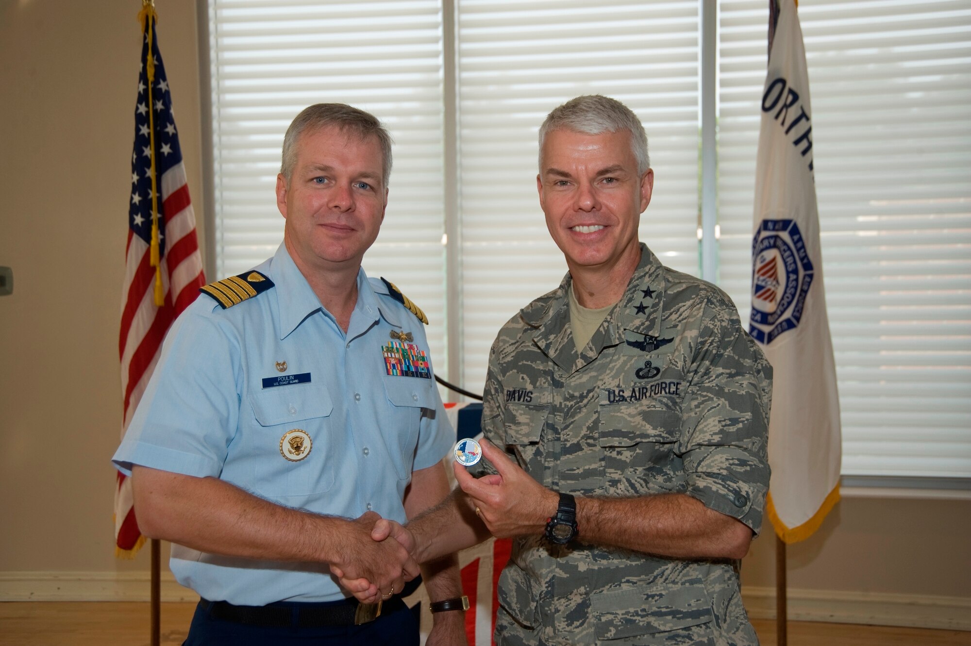 In honor of the Coast Guard's birthday Aug. 4, Capt. Steve Poulin, operational commander, Headquarters USCG Sector Mobile, Ala., presents a commemorative coin to Maj. Gen.C.R. Davis, Air Armament Center commander during a Military Officers Association breakfast here Aug. 5. The service has been the longest continuous sea service in the U.S. since 1790. The sector in Mobile covers an area of operation from Gulf Port, Miss., to Tallahassee, Fla. (U.S. Air Force photo)