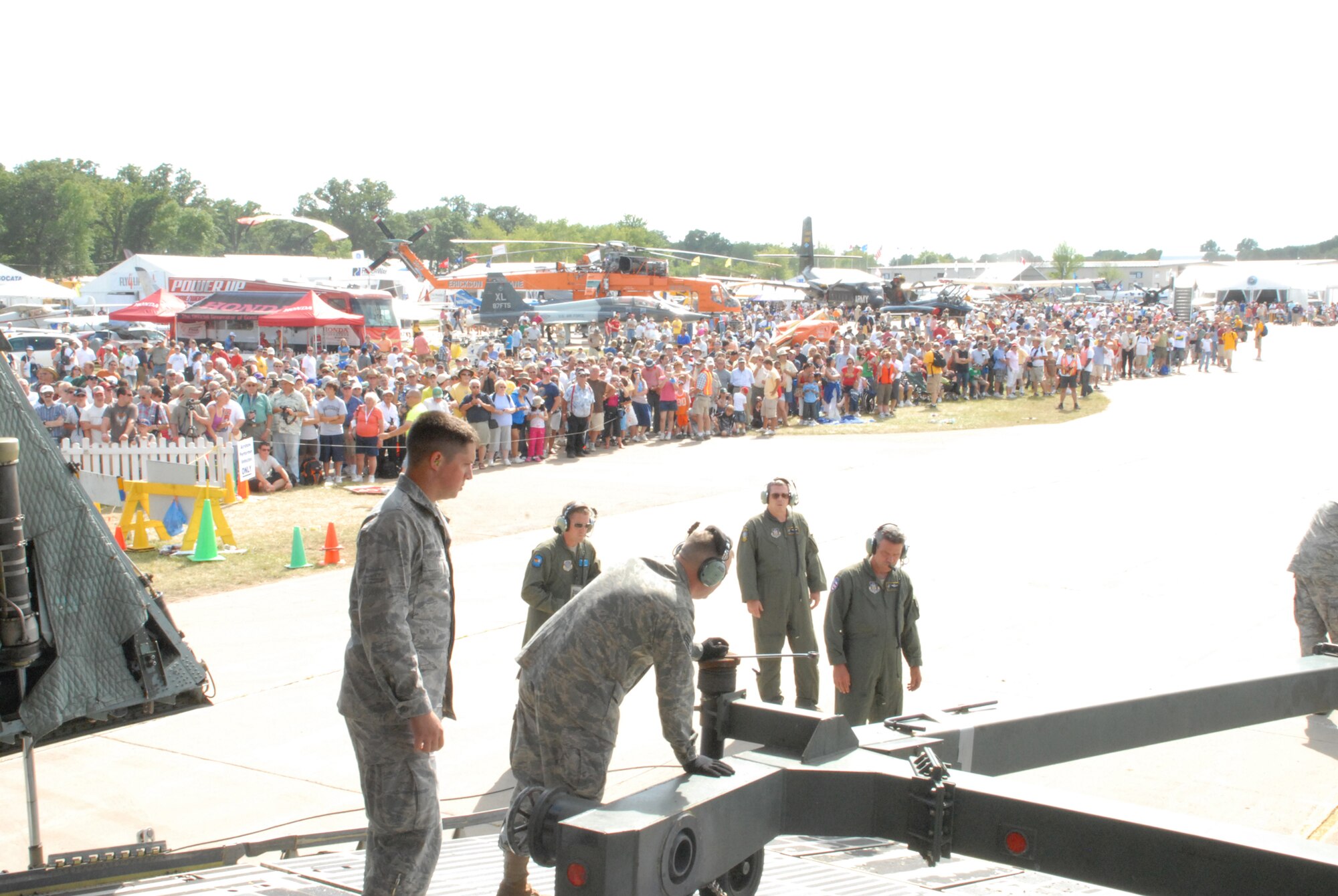 Team Dover members unload the C-5M Super Galaxy as EAA AirVenture Oshkosh visitors watch.  More than 10,000 guests toured the aircraft during The Spirit of Normandy?s two-day visit to the event.  (U.S. Air Force photo/Staff Sgt. Chad Padgett)