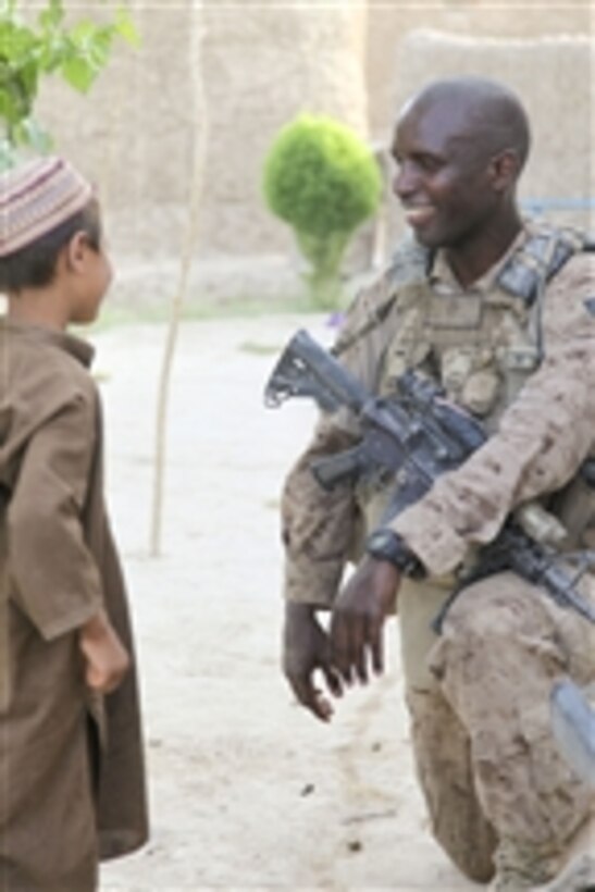 U.S. Marine Corps Staff Sgt. Jonathan Collins with Alpha Company, 1st Battalion, 5th Marine Regiment laughs and jokes with an Afghan boy during a key leader engagement in the Nawa district of Helmand province, Afghanistan, on July 30, 2009.  Marines with 1st Battalion, 5th Marine Regiment, Regimental Combat Team 3, 2nd Marine Expeditionary Brigade-Afghanistan are deployed to support NATO's International Security Assistance Force and will participate in counterinsurgency operations.  They will train and mentor Afghan National Security Forces to improve security and stability in the country.  