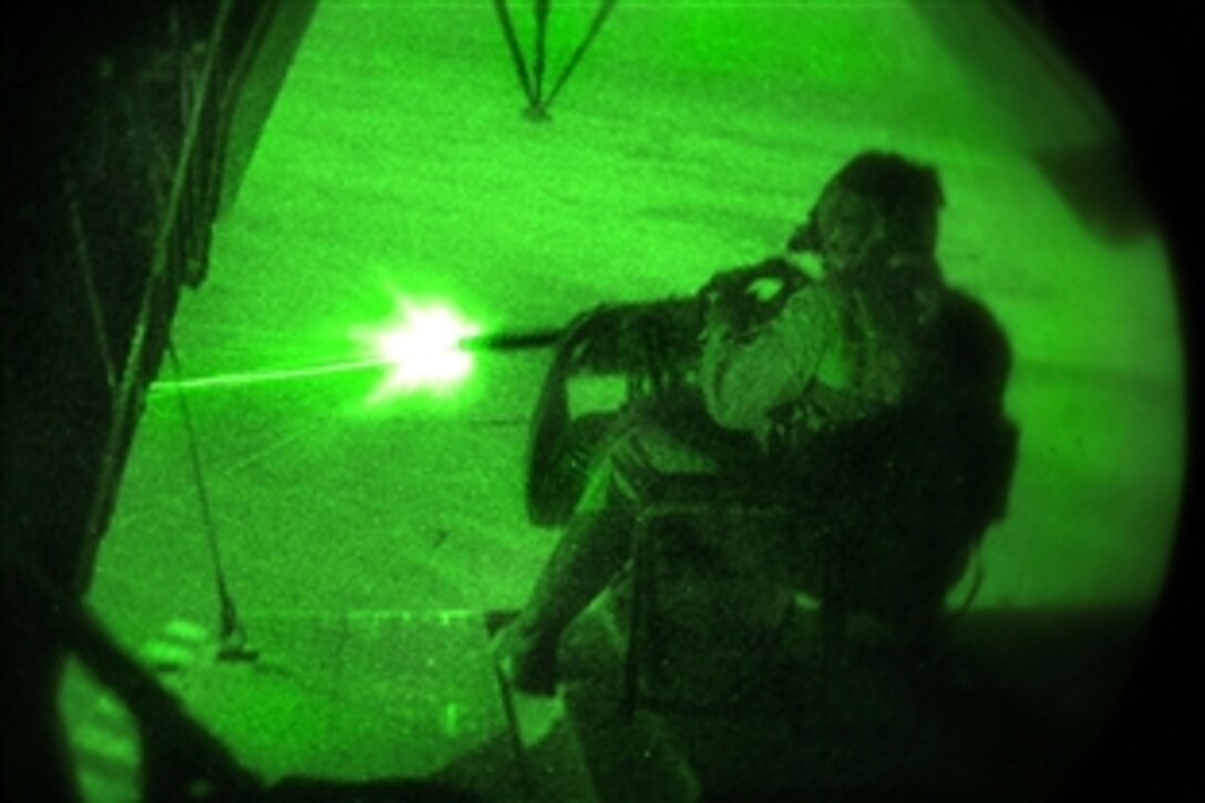 As seen through a night-vision device, U.S. Marine Corps Sgt. Zachary Ritter test fires the tail gun in a CH-53D Sea Stallion helicopter during a night flight over Helmand province, Afghanistan, Aug. 3, 2009. Ritter is assigned to Marine Heavy Helicopter Squadron 362. 