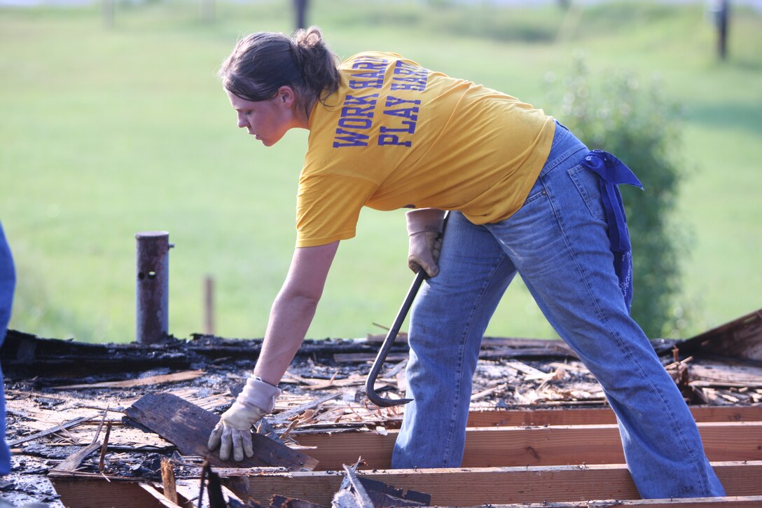 A Marine with 8th Engineer Support Battalion moves pieces of wood as she breaks it apart with a crowbar on the roof of the Salvation Army building, August 8.