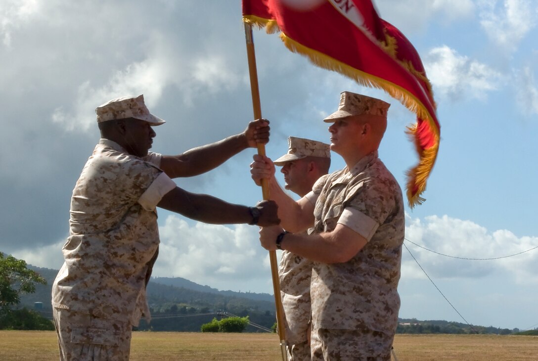 Sergeant Maj. James Roberts, Headquarters and Service Battalion, U.S. Marine Corps Forces, Pacific, passes the battalion colors to inbound Col. Al Thoma at Bordelon Field Aug. 7. (Official U.S. Marine Corps photo by Cpl. Achilles Tsantarliotis)(Released)