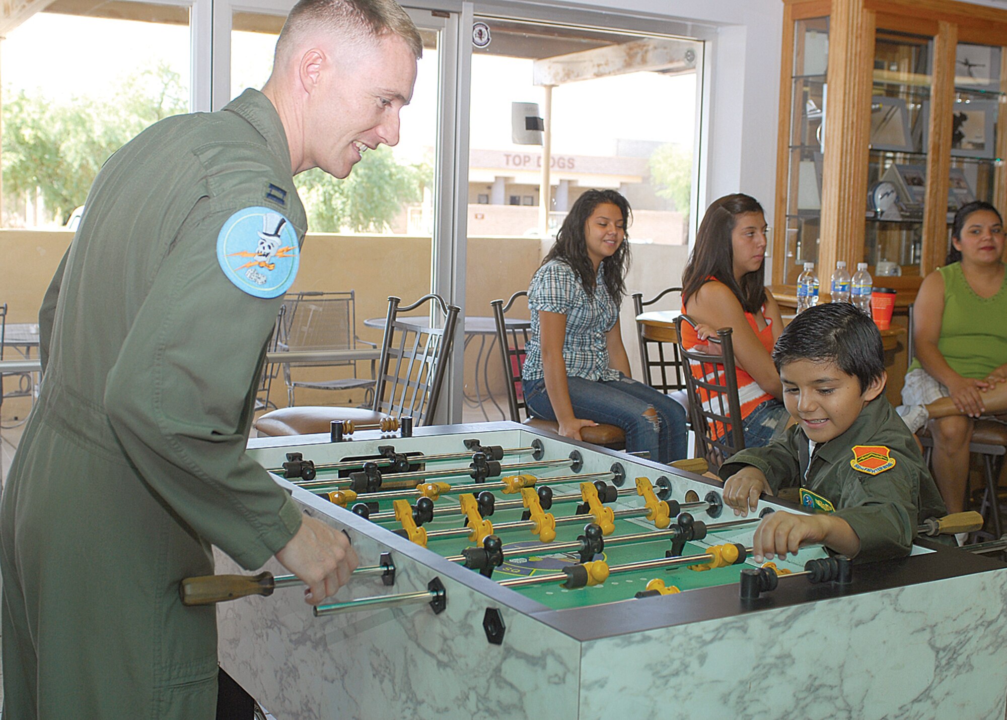 Pilot-for-a-day Aron "Archer" Olivares, 9, plays Foosball with Capt. Michael McGrew, 310th Fighter Squadron F-16 pilot, in the break room during his visit to Luke Air Force Base July 31. (U.S. Air Force photo by Senior Airman Tracie Forte)