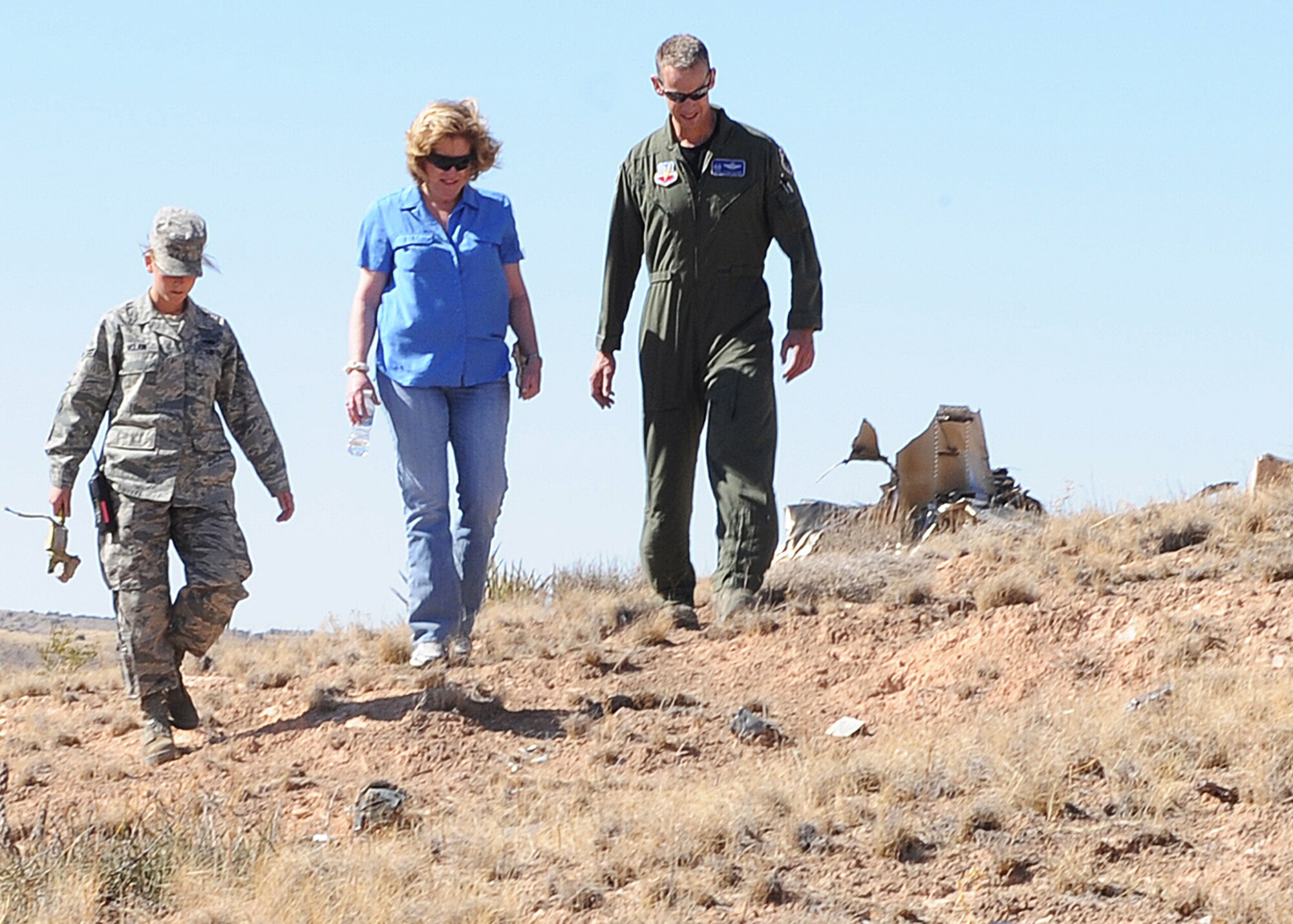 HOLLOMAN AIR FORCE BASE, N.M. --Col. Michael Stapleton, 49th Operations Group commander, Airman 1st Class Kelly McClain, 49th Logistics Readiness Squadron and Lisa Thompson-Lester trek to the crash site of Capt. Benjamin Thompson March 23, at the Red Rio Range, N.M.  The family was taken on a tour of Holloman and of the crash site of Captain Thompson on the 42nd anniversary of the crash. (U.S. Air Force photo by SrA John D. Strong II)