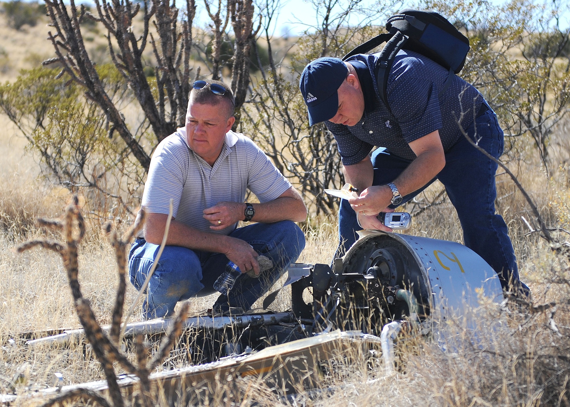 HOLLOMAN AIR FORCE BASE, N.M. -- Robert Thompson and Benjamin Thompson observe the remains of the F-100 plane their father, Capt. Benjamin Thompson, crashed in 40 years earlier at the Red Rio Range, N.M. The family was taken on a tour of Holloman and of the crash site of Captain Thompson on the 42nd anniversary of the crash. (U.S. Air Force photo by SrA John D. Strong II)   