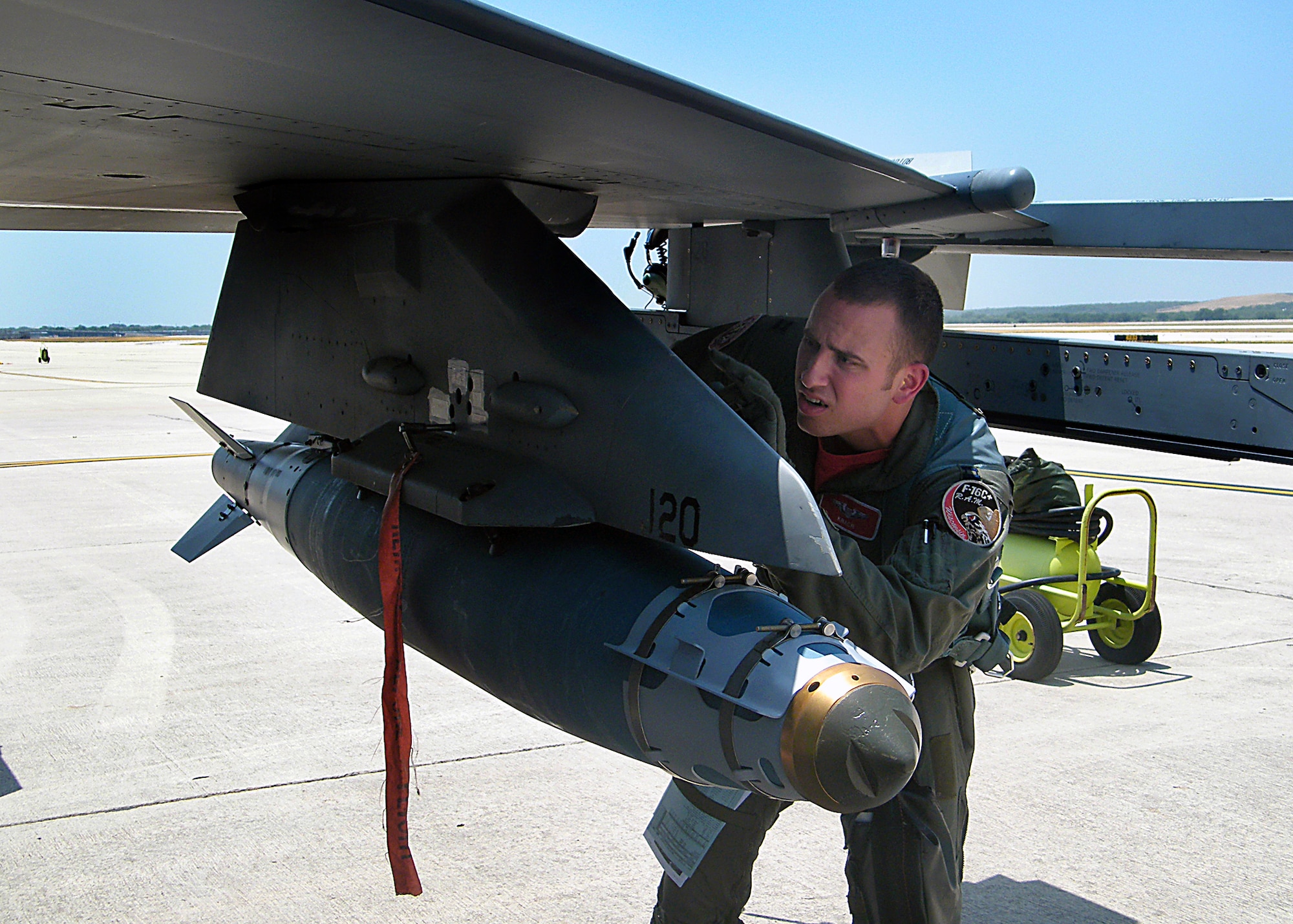 Capt. Keith “KRACR” Krejchik, an F-16 instructor pilot with the Wisconsin Air National Guard’s 115th Fighter Wing, inspects a GBU-38 Joint Direct Attack Munition (JDAM) just prior to flying from Kelly Field, Lackland Air Force Base, Texas, to the McMullen Target Complex in South Texas on July 17, 2009. Capt. Krejchik is undergoing instructor pilot upgrade training with the 149th Fighter Wing, Texas Air National Guard. (Air National Guard photo/SSgt Phil Fountain)(RELEASED)

