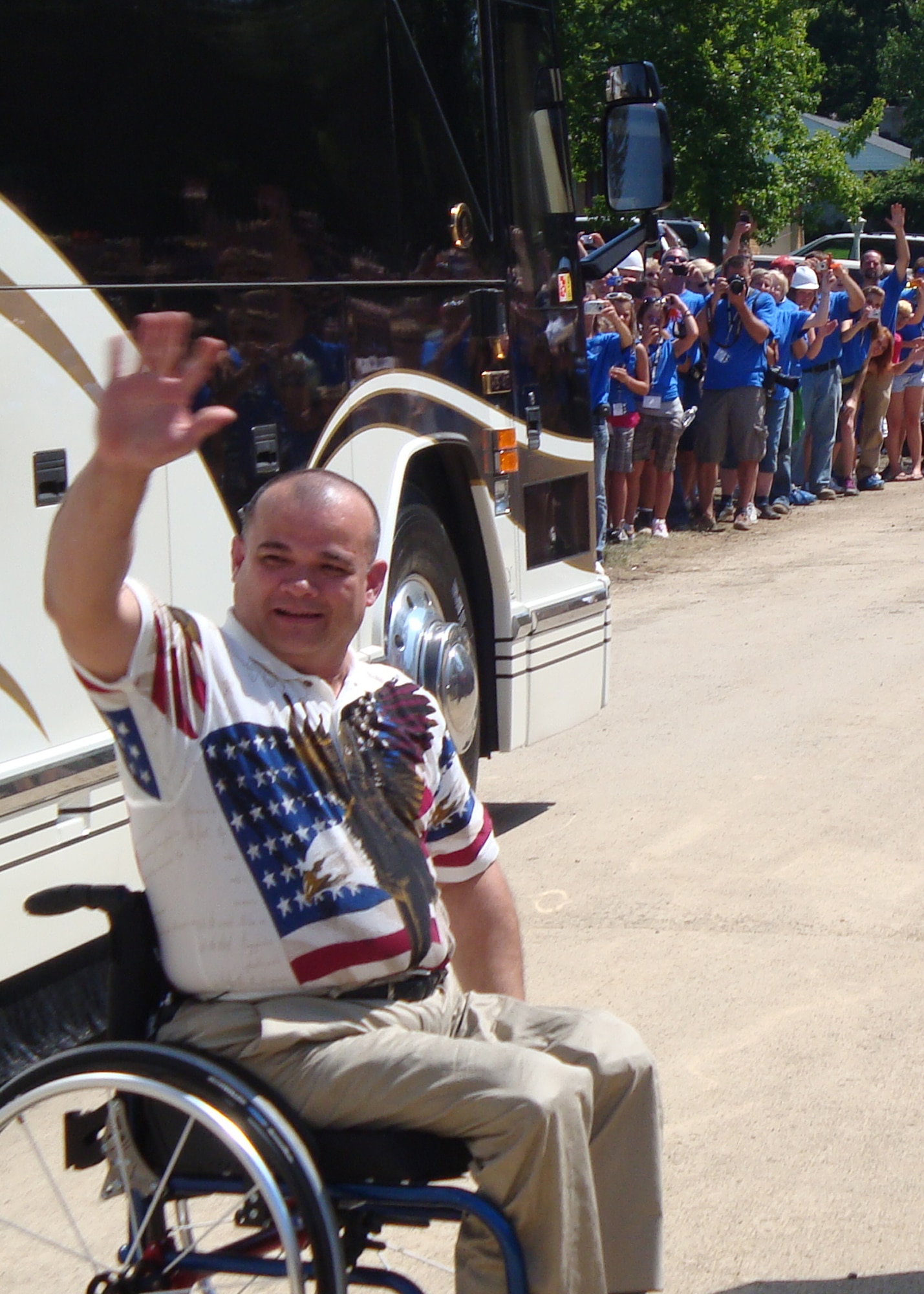 James Terpenning waves to thousands of volunteers and onlookers after seeing his new home unveiled as part of the television show "Extreme Makeover: Home Edition." (Air Force photo by Ron Fry)