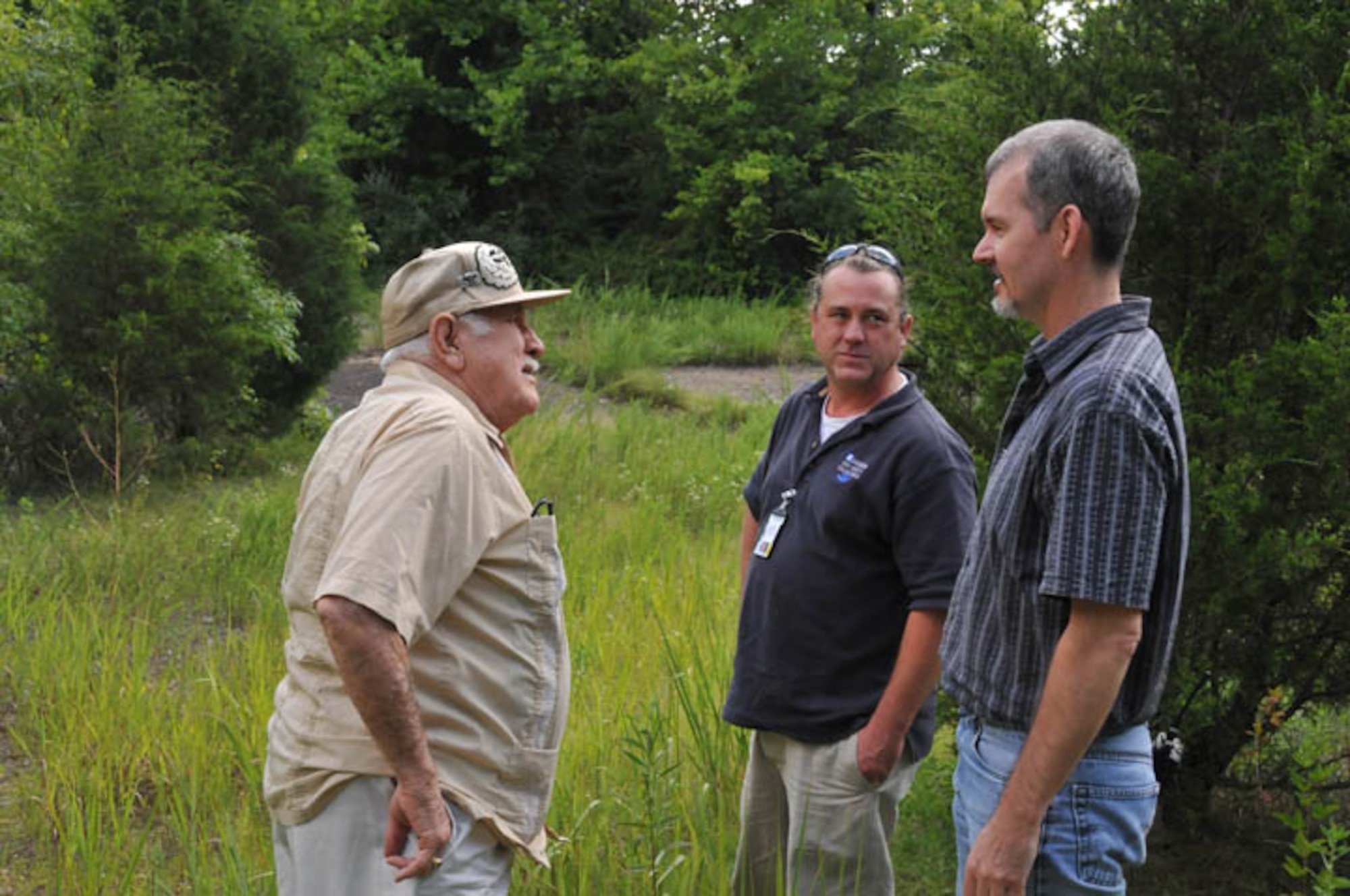 Conservation Biologist John Lamb and Base Archeologist Shawn Chapman show former Army soldier Jack Ariola the grounds where the former theater at Camp Forrest was located. Ariola trained here for WWII.  All that remains of the 85,000 acres of Camp Forrest are a few access roads, brick chimneys and concrete foundations. Approximately 40,000 acres became Arnold Air Force Base in 1951. (Photo by David Housch)