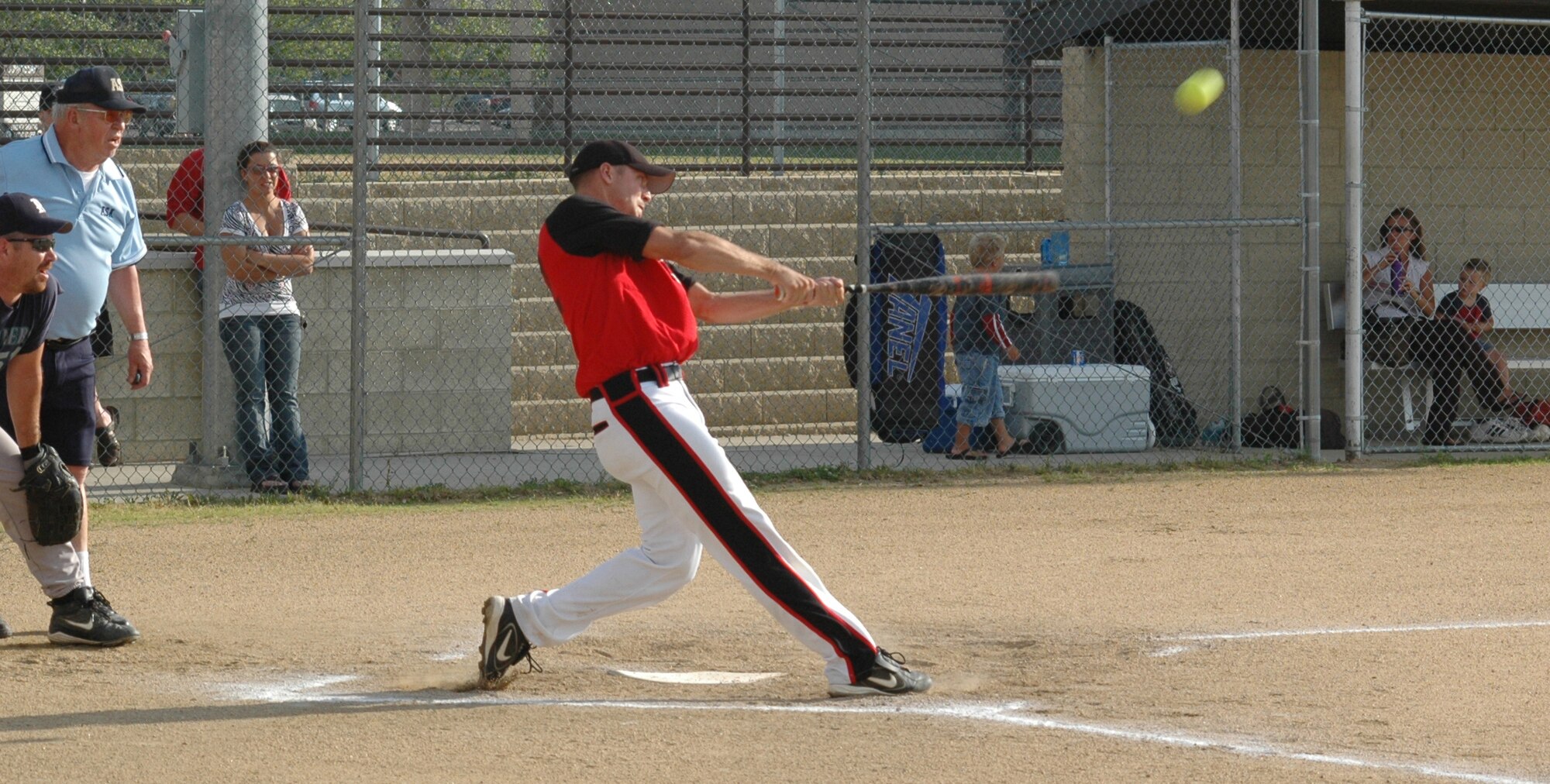Tyson Mollenbeck, 12th Missile Squadron, smashes a ball into the outfield during a 6 p.m. intramural softball playoff game Aug. 4 against the 341st Security Forces Group team on field 2. (U.S. Air Force photo/Senior Airman Dillon White)