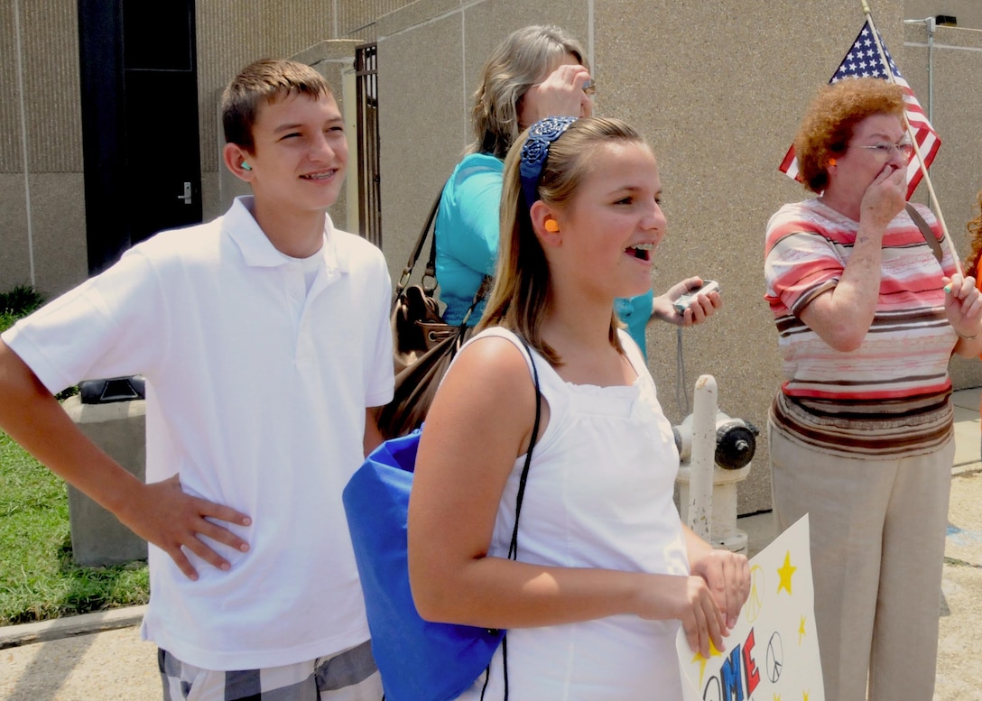 Payne, (left) Presley (middle) and Jeanne Hanberry, and Rene McCaleb (back) watch as the aircraft carrying Master Sgt. Brad Hanberry, 403rd Security Forces Squadron, lands Aug. 6 at Keesler Air Force Base, Miss. Sergeant Hanberry, who is the uncle of Payne and Presley, son of Jeanne, and brother of Rene, deployed to Kirkuk, Iraq in January along with 25 other 403 SFS members. The family lives in Petal, Miss.  (U.S. Air Force photo by Staff Sgt. Tanya King)