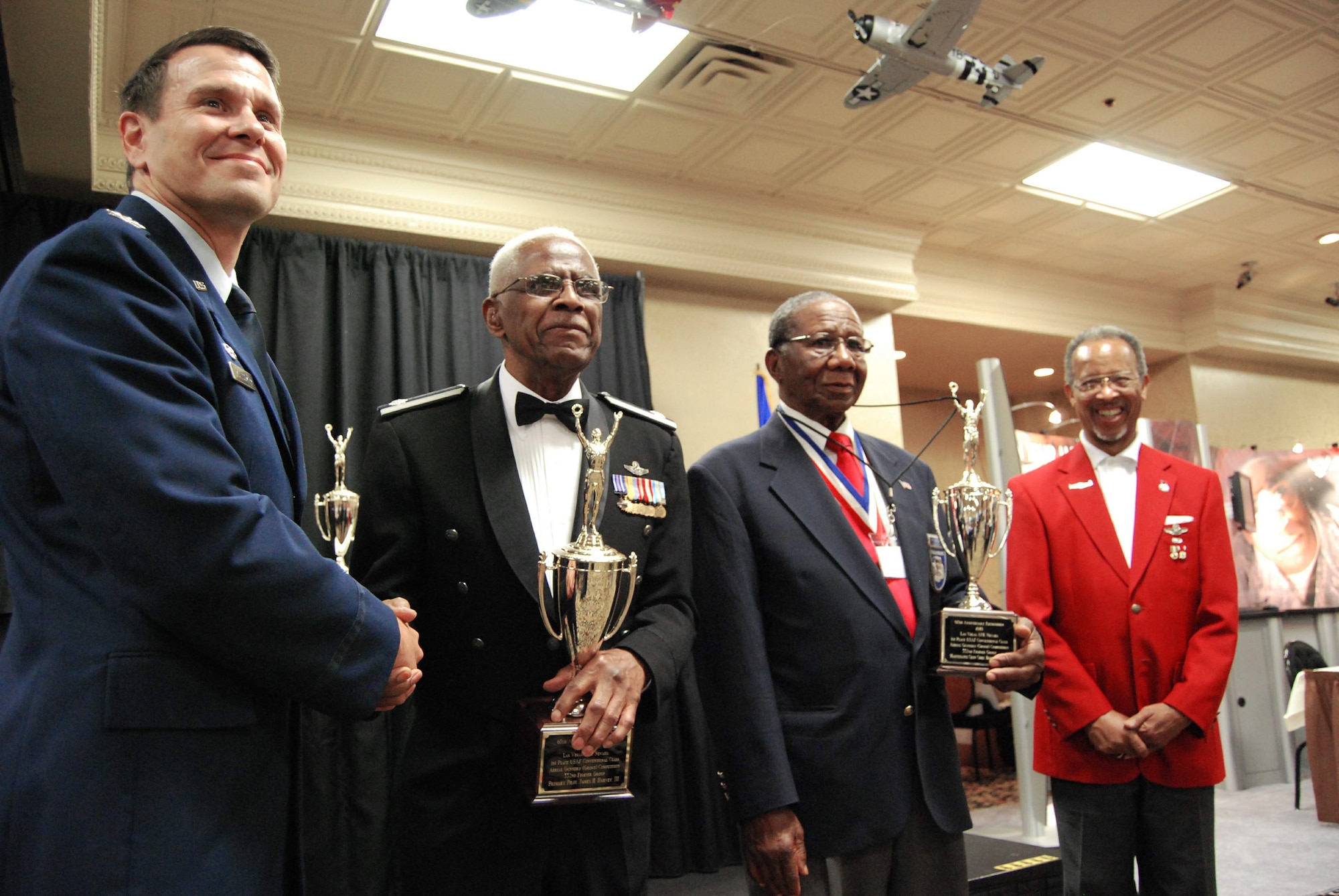 Col. John Montgomery (left) pauses for a photo with retired Lt. Col. James Harvey, retired Chief Master Sgt. Buford Johnson and Tuskegee Airmen Inc. President Russell Davis during the 60th anniversary recognition ceremony of the "Gunsmoke" competition for sharp shooters Aug. 6 at the Palace Station Hotel in Las Vegas. The event occurred during the 38th annual TAI National Convention Aug. 6 through 9. Colonel Montgomery is the Range Wing commander at Nellis Air Force Base, Nev. (U.S. Air Force photo/Tech. Sgt. Amaani Lyle)