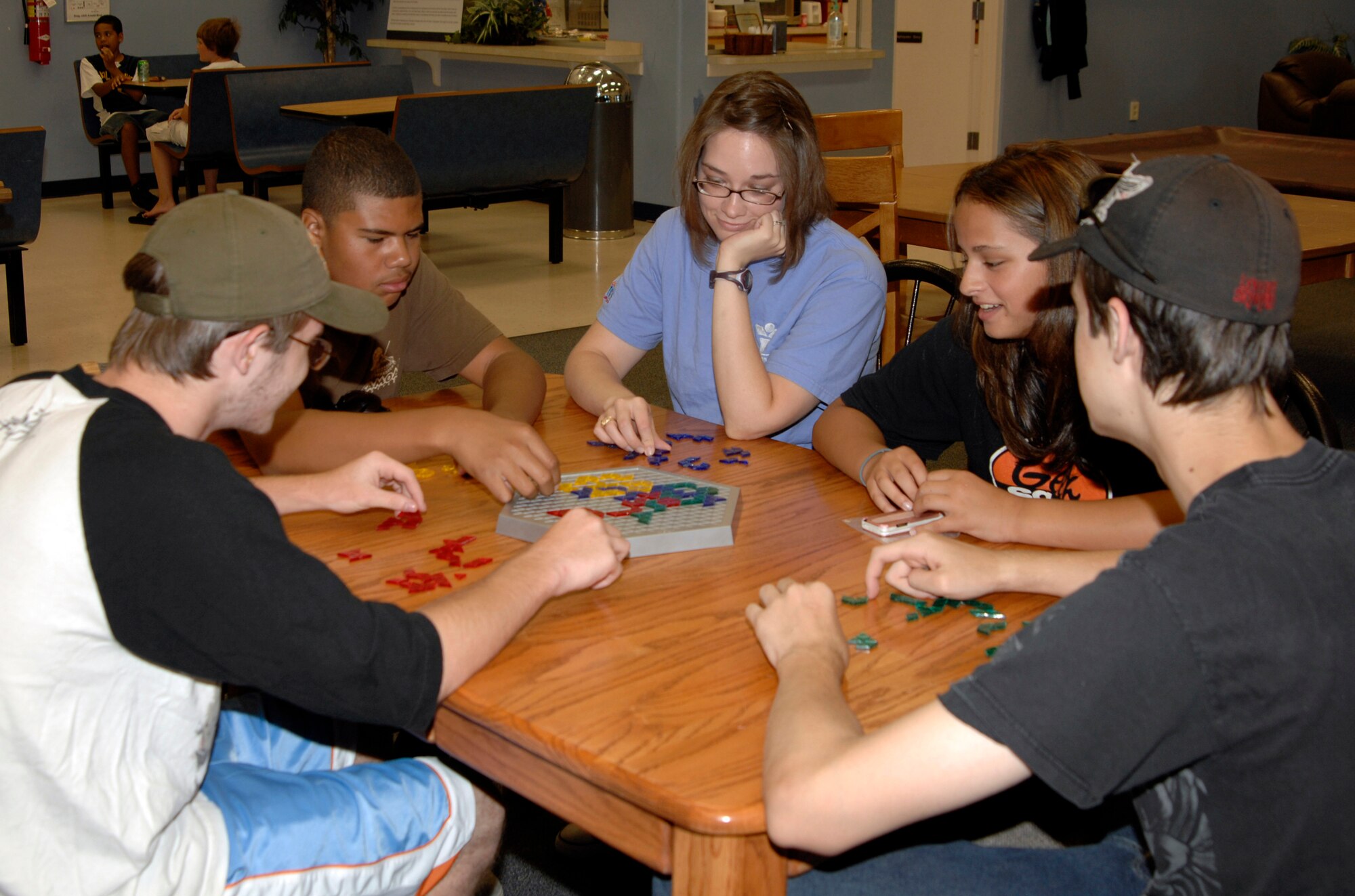 Janessa Thompson, (middle) Youth Center employee, plays a game with McConnell youth, Aug. 4. The Youth Center is open year-round and the staff provides a place for the school age base youth to interact every evening and weekend, to include a snack bar, games, and gymnasium. (U.S. Air Force photo/Senior Airman Laura Suttles)