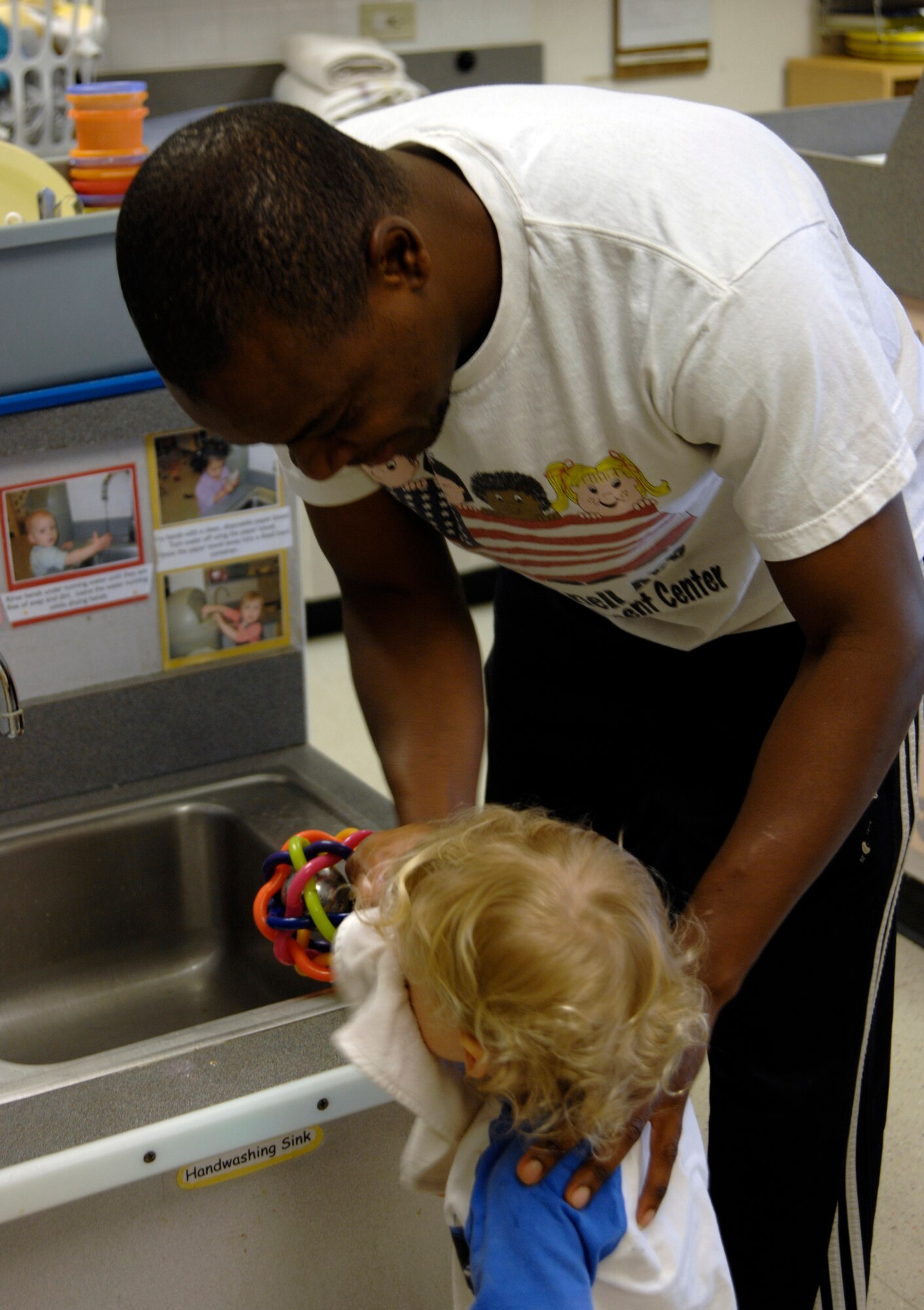 Terrell Hodge, childcare provider, washes Ethan Crandell’s face after lunch at the Child Development Center, Aug. 4.  The CDC provides a safe environment for dependents of McConnell members to learn and grow. (U.S. Air Force photo/ Senior Airman Laura Suttles)
