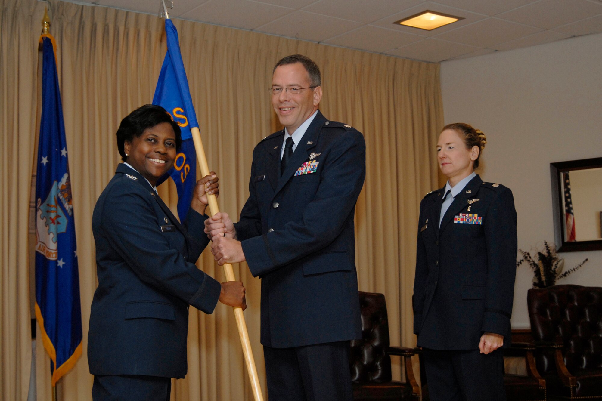 Lt. Col. Dale Grey accepts command of the 341st Medical Operations Squadron from Col. Leslie Dixon, 341st Medical Group commander, July 31 at the Grizzly Bend Club. Lt. Col. Martha Johnston, outgoing 341st MOS commander looks on. (U.S. Air Force photo / Beau Wade)