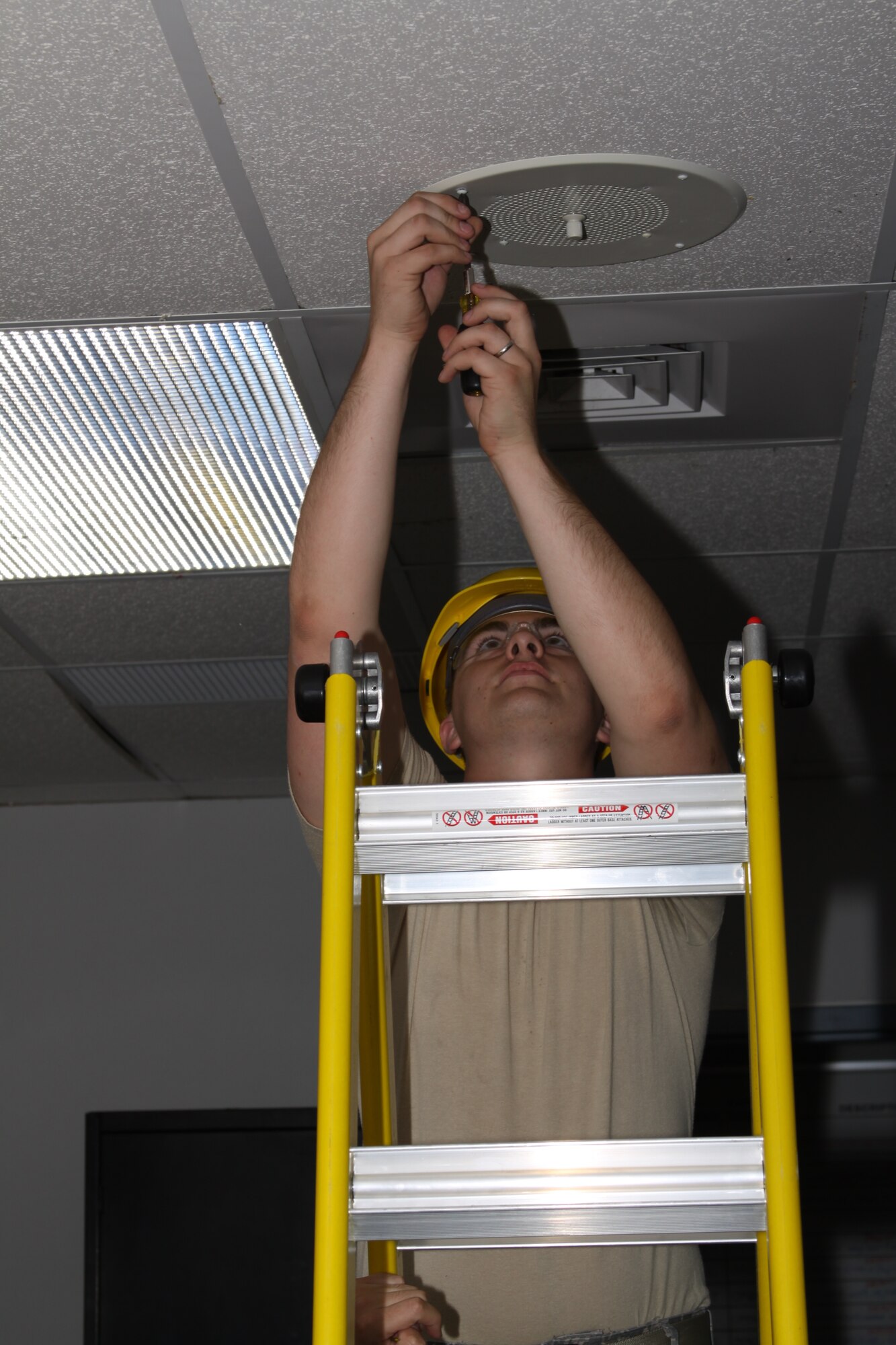 SrA Kevin Gibson installing a speaker for the building paging system at Savannah, GA in July 