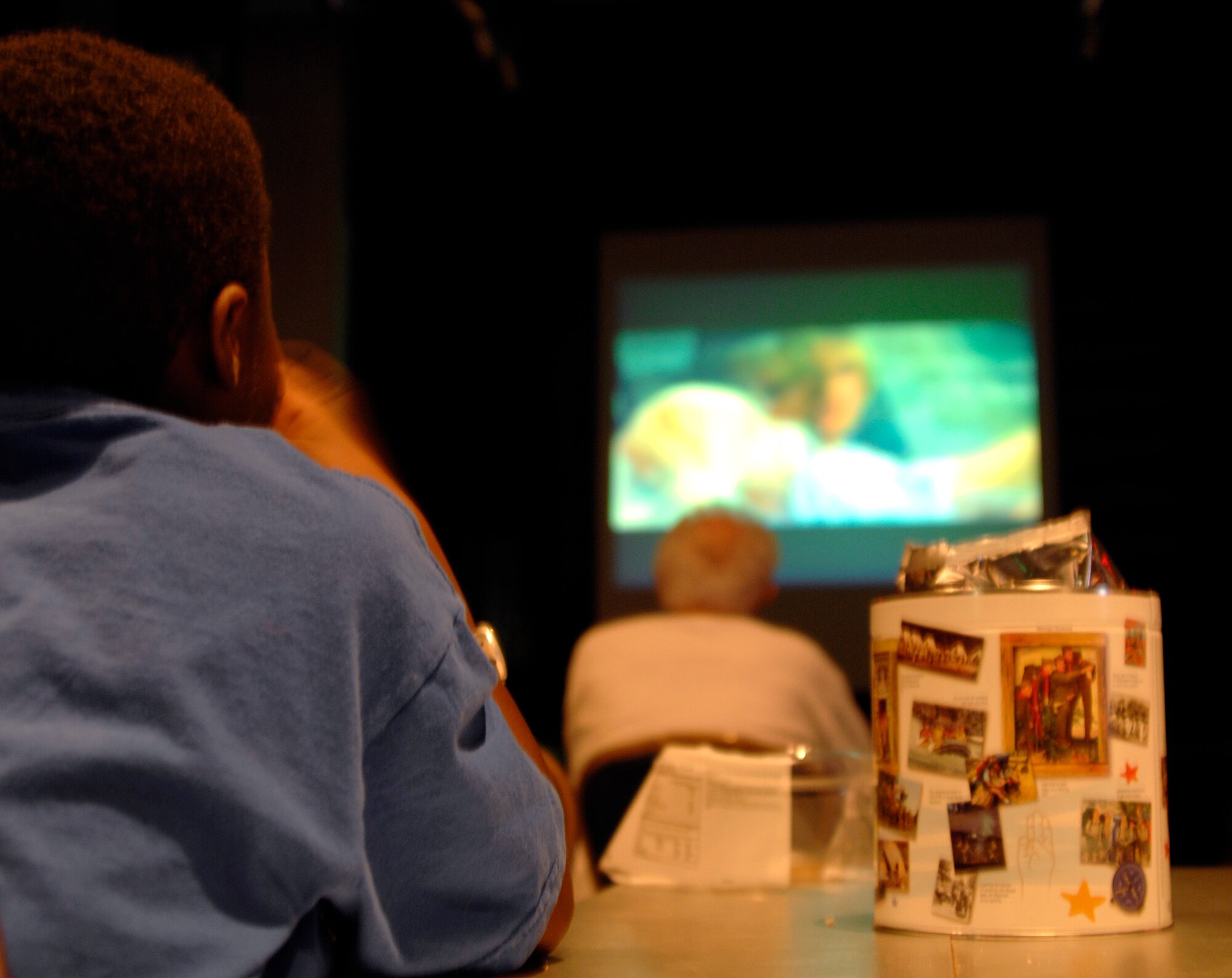 Aidan Coleman, nine, son of Lt. Col. Anthony Coleman, 384th Air Refueling Squadron, watches a movie with his mother and sister at McConnell AFB, Kan., on Aug. 3. Every Monday during the Match-up program season, the 22nd Force Support Squadron, hosts the Match-up Movie program for members of McConnell. The last movie of the season will be shown Aug. 10. (U.S. Air Force photo/Senior Airman Laura Suttles)