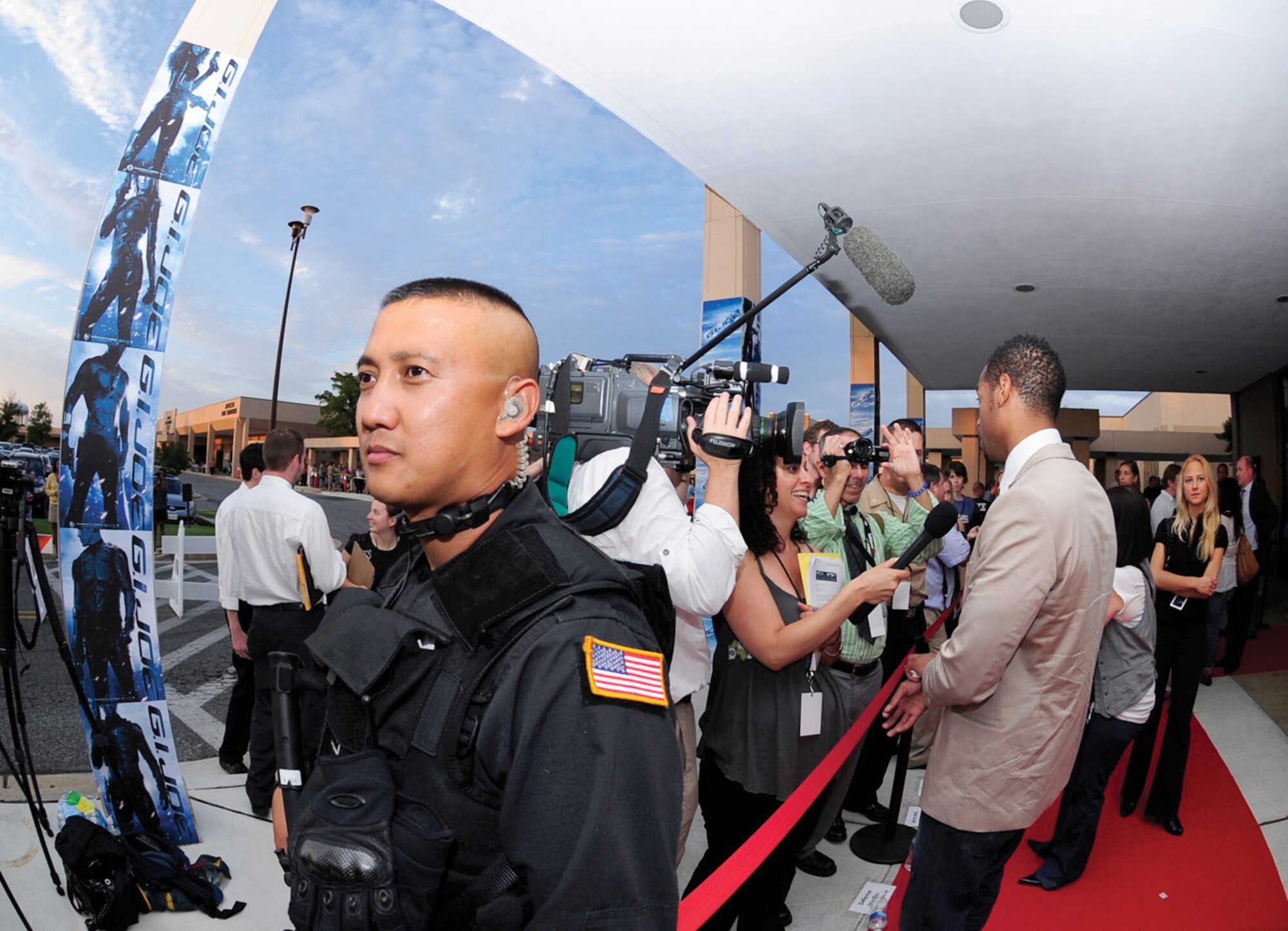 Technical Sgt. ElliJohn Macaraeg, 316th Security Forces Squadron military working dog trainer, provides security as actor Marlon Wayans takes part in an interview on the red carpet prior to the premiere of “G.I. Joe: The Rise of Cobra” at the Andrews base theater July 31. The movie is scheduled to hit theaters today. (U.S. Air Force photo/ Staff Sgt. Keyonna Fennell)