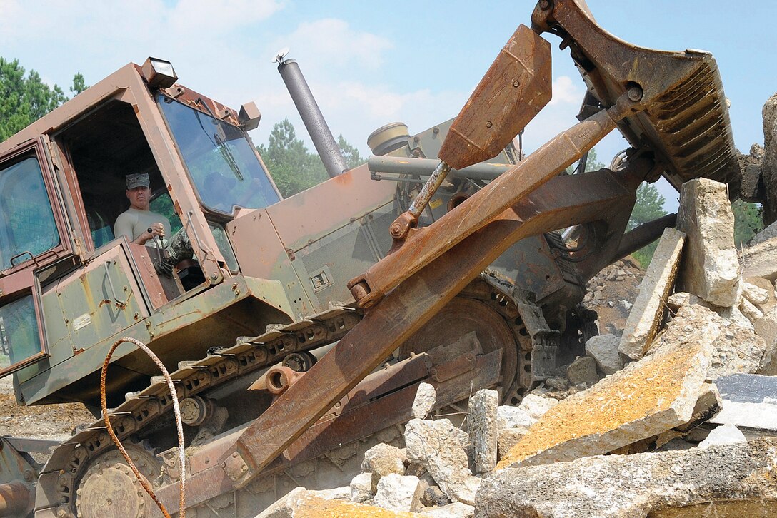 Colonel Steven Shepro, 316th Wing/Andrews commander, clears debris with a bull dozer on Andrews during a weekly tactical leadership visit where wing leadership takes time to learn more about different jobs on base. The hands-on participation allows wing leadership to better understand the needs of Airmen and functions of 
different squadrons on base. (U.S. Air Force photo/ Senior Airman Giang Nguyen)