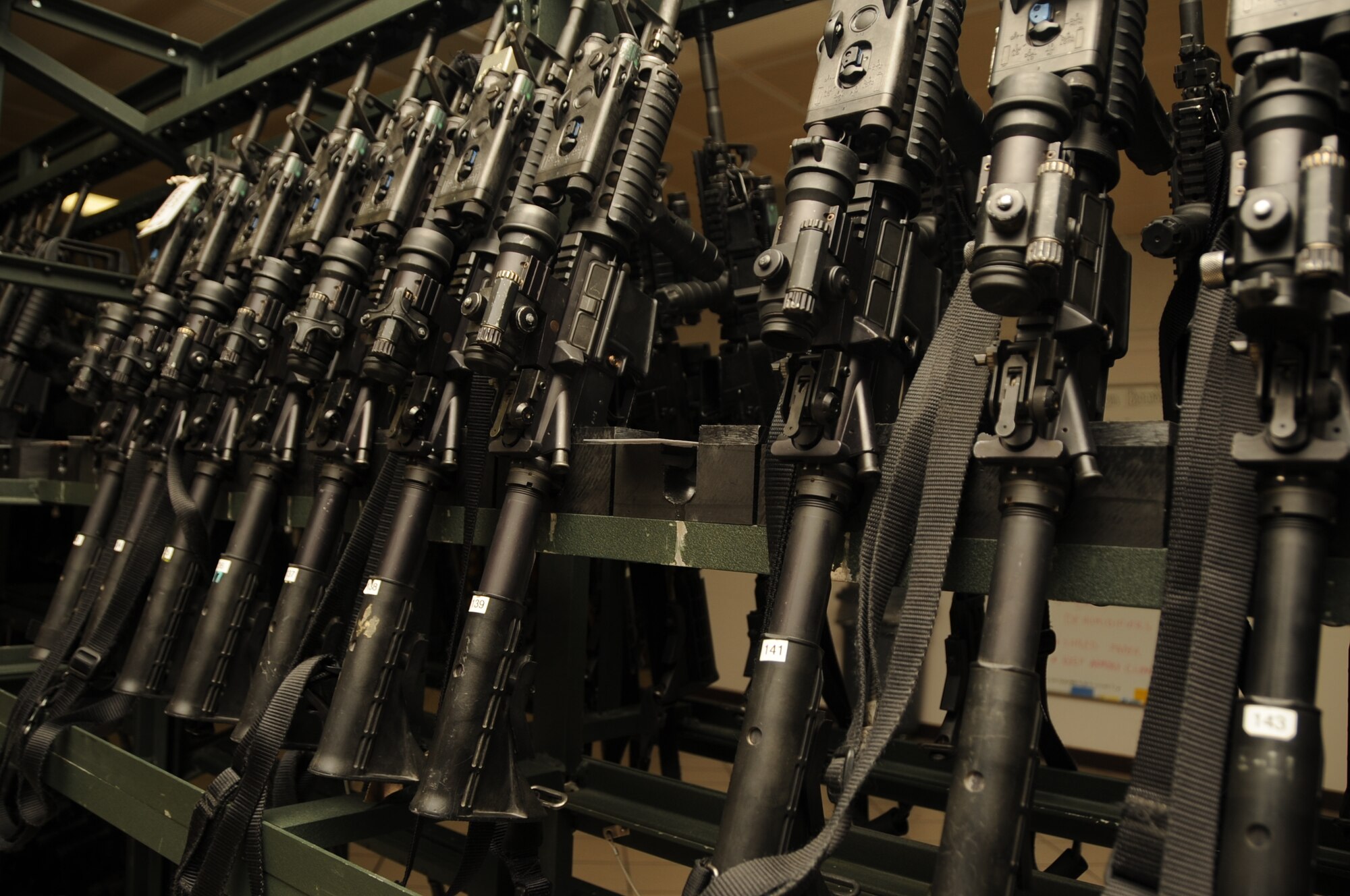 M4 Carbine assault rifles lined up in storage at the 28th Security Forces Squadron Armory, August 6.  The 28 SFS carries a variety of weapons such as the M4 carbine assault rifle, M-240B machine gun, M-870 shotgun and M-24 sniper rifle, just to name a few. (U.S. Air Force photo/Airman 1st Class Anthony Sanchelli)