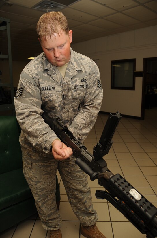 Staff Sgt. Jeremy Douglas, 28th Security Forces Squadron armory NCO in charge, clears an M-249 Semi-Automatic Weapon here, August 6.  The M-249 SAW is cleared to ensure the weapon is not stored while still loaded. (U.S. Air Force photo/Airman 1st Class Anthony Sanchelli)