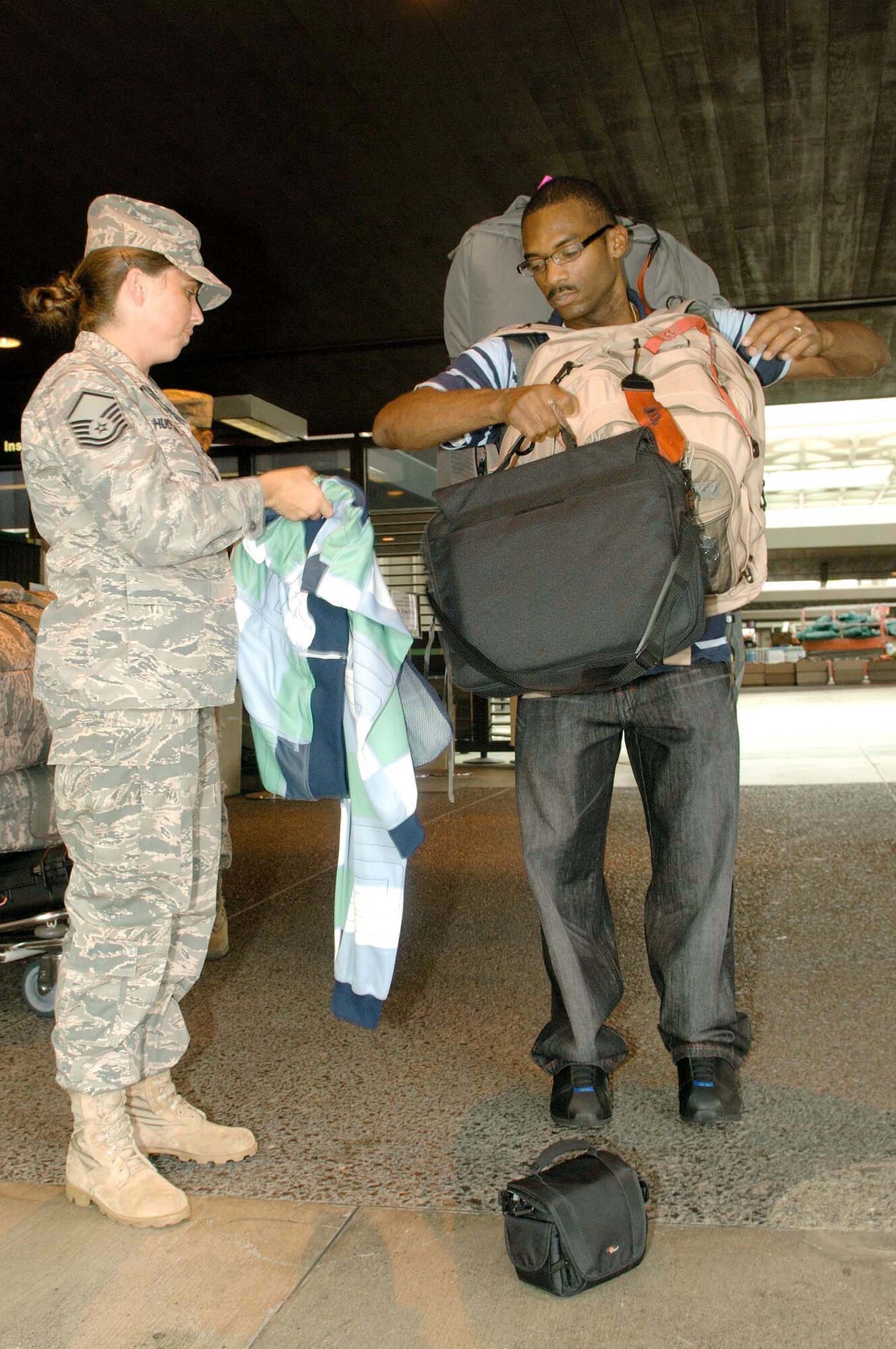 Master Sgt. Janet Hudson helps Tech. Sgt. Dedric Brown with his gear prior to leaving for his deployment July 31 at Honolulu International Airport in Hawaii. Sergeant Brown is one of 54 reservists from the 624th Civil Engineer Squadron being mobilized to deploy to Afghanistan. Sergeant Hudson is assigned to the 624th Regional Support Group Family Support Flight, and Sergeant Brown is a 624th CES member. (U.S. Air Force photo/Mark Bates) 
