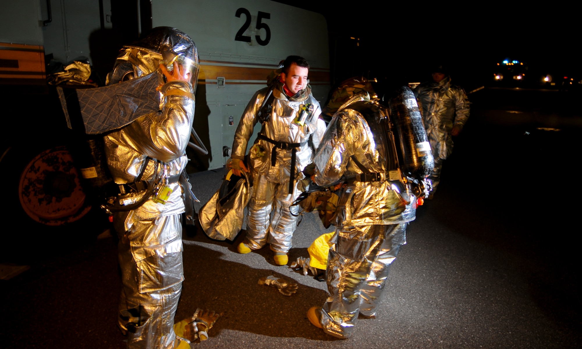 SPANGDAHLEM AIR BASE, Germany -- Firefighters from the 52nd Civil Engineer Squadron remove their helmets after being instructed to go from Mission Oriented Protective Posture 4 to MOPP 2 Aug. 5. Members of the 52nd Fighter Wing practiced donning chemical protective gear as part of the wing’s Phase II exercise to prepare for a NATO Tactical Evaluation in June 2010. (U.S. Air Force photo/Airman 1st Class Nathanael Callon)