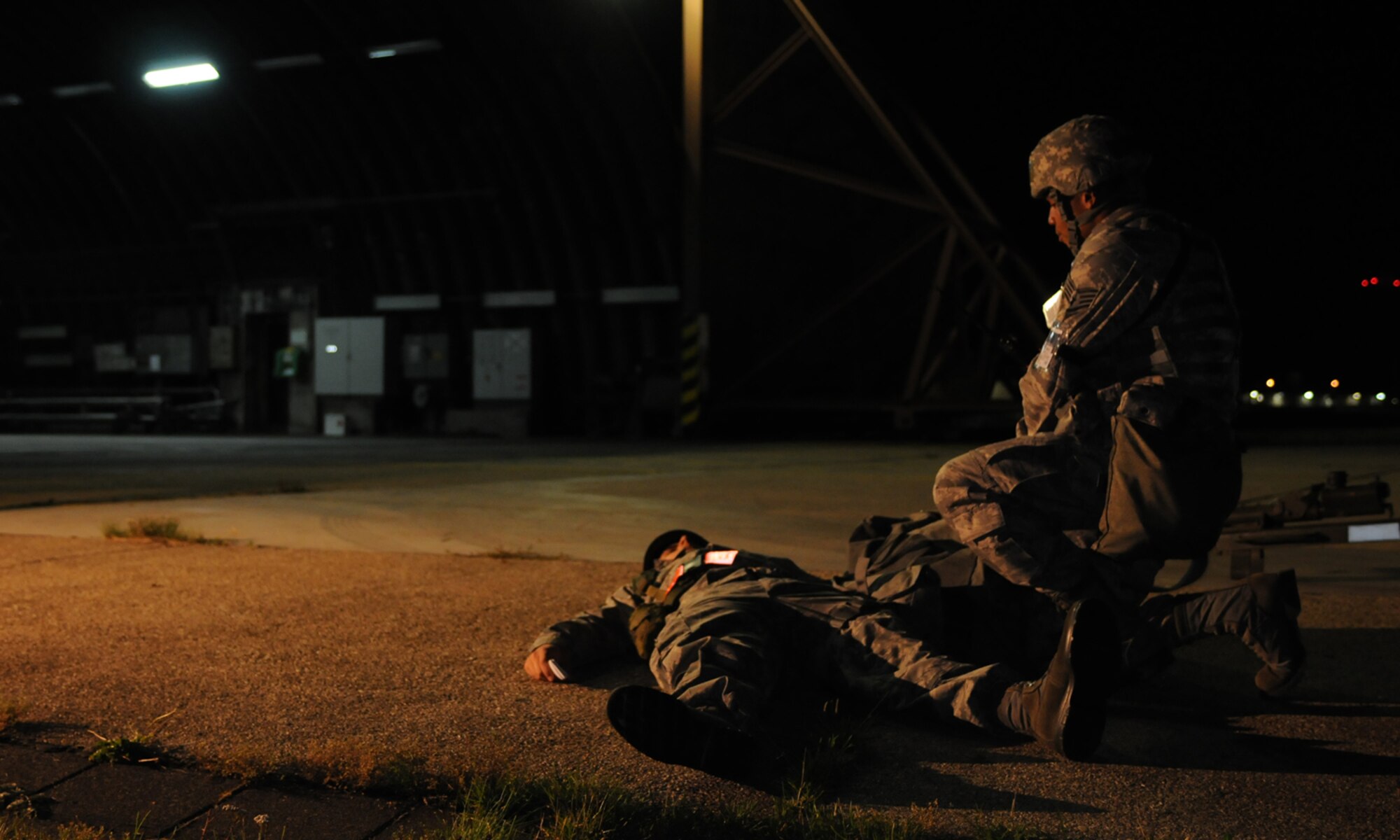 SPANGDAHLEM AIR BASE, Germany -- Staff Sgt. Christopher Manning, 52nd Security Forces Squadron, provides care to a wounded Airman outside a hardened aircraft shelter here Aug. 4. Members of the 52nd Fighter Wing had to performed simulated immediate medical assistance during the Phase II exercise held Aug. 4-7, to prepare for the NATO Tactical Evaluation next year. (U.S. Air Force photo/Airman 1st Class Nathanael Callon)