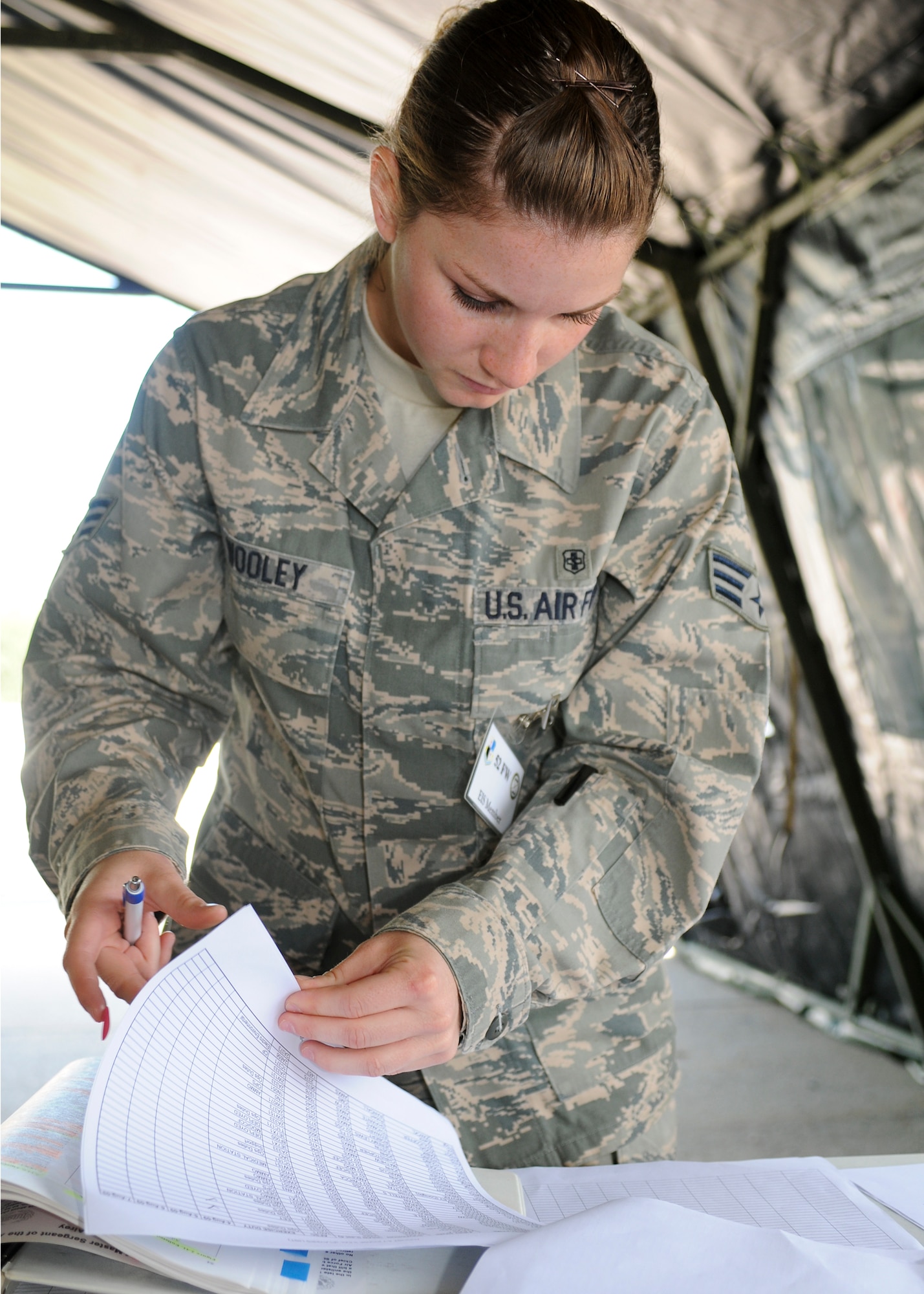 SPANGDAHLEM AIR BASE, Germany -- Senior Airman Sarah Wooley, 52nd Dental Squadron, searches for personnel on an entry authorization list at an exercise indoctrination station Aug. 4. The list controls who is allowed into the tactical area of responsibility here during the 52nd Fighter Wing’s Phase II exercise. (U.S. Air Force photo/Airman 1st Class Nathanael Callon)