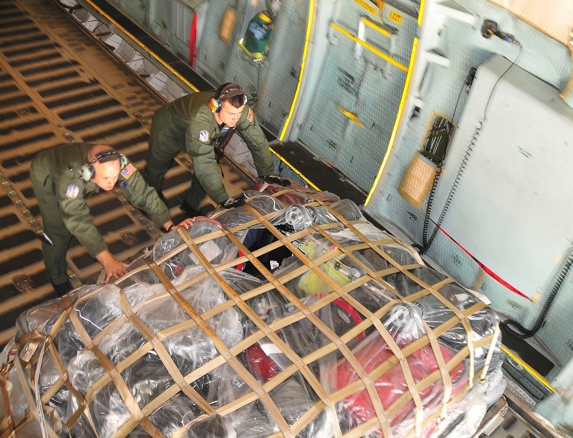 RAMSTEIN AIR BASE, Germany - Tech. Sgt. Ryan Johnson, left, and Senior Airman Michael Gaudette move palletized baggage toward the tail of a C-5 Galaxy at Ramstein Air Base, Germany, en route to Bagram Airfield. Sergeant Johnson and Airman Gaudette are loadmasters with the 337th Airlift Squadron, located in Westover, Mass. (U.S. Air Force photo/Staff Sgt. Daniel Bowles)