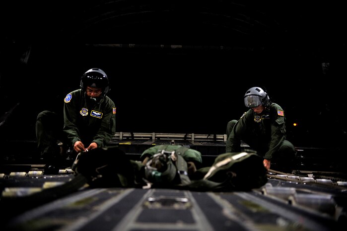 Staff Sgt. Mark Johnson and Senior Airman Jacob Hitefield prepare the rigging for a heavy pallet extraction for an airdrop mission July 29. Three aircraft made up the formation dropping five platforms and more than 30 Airmen. Sergeant Johnson and Airman Hitefield are loadmasters with the 14th Airlift Squadron. (U.S. Air Force photo/Master Sgt. Jeremy Lock)