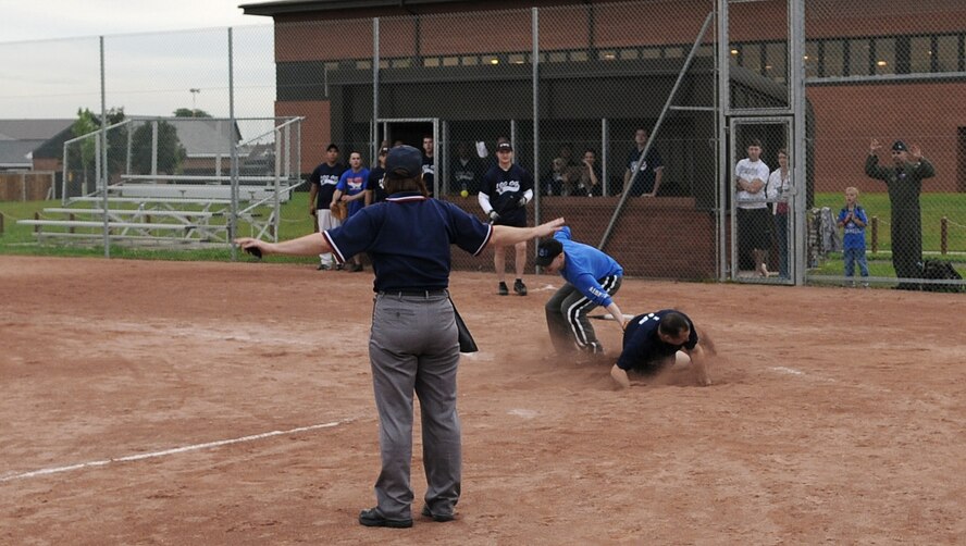 RAF MILDENHALL, England -- Michael Frymire, 100th Operations Group player, slides into home plate to narrowly beat out Thomas Finneran, 95th Reconnaissance Squadron player, and contribute to the 100th OG?s 19-2 win in the Mildenhall Intramural Softball Championship Aug. 4. The 100th OG took the championship title after a two-game run against the combined 95th Reconissance Squadron and 488th Intelligence Squadron team. (U.S. Air Force photo by Senior Airman Thomas Trower)