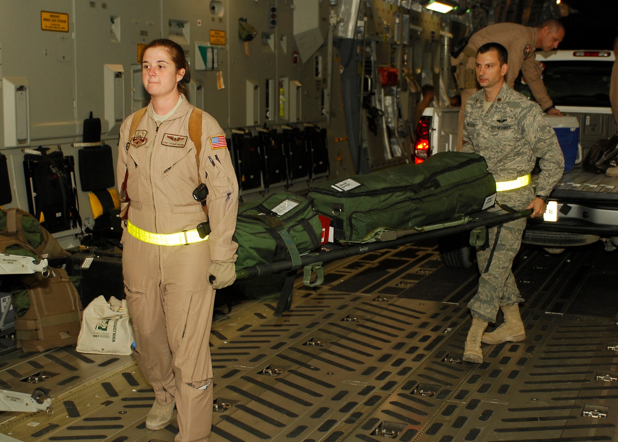 BAGRAM AIRFIELD, Afghanistan - Staff Sgt. Tiffany Brown, an Aeromedical Evacuation Technician (left), and Major Christopher Matlack, a 19-year veteran flight nurse (right), both from the 455th Expeditionary Aeromedical Evacuation Squadron, load a litter full of gear and life saving equipment onto a C-17 Globemaster III, here Aug. 4. Both Sgt. Brown and Maj. Matlack are from the 455th Expeditionary Aeromedical Evacuation Squadron, which is in charge of medically evacuating a large percentage of the wounded in Afghanistan. (U.S. Air Force photo/Senior Airman Felicia Juenke)