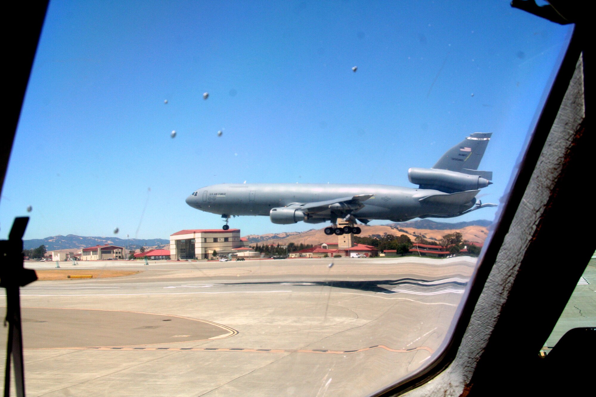 Through the window of a KC-10 Extender, another KC-10 comes in for a landing on the flightline at Travis Air Force Base, Calif., on Aug. 4, 2009.  The KC-10 is one of Air Force's and Air Mobility Command's air refueling aircraft that helps provide global reach and the Air Force to fly, fight and win...in air, space and cyberspace.  (U.S. Air Force Photo/Tech. Sgt. Scott T. Sturkol)