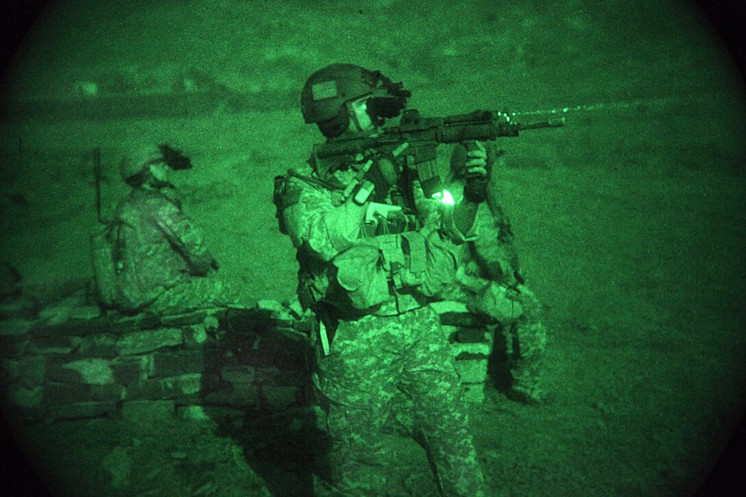 As seen through a night-vision device, a U.S. Air Force tactical air controller pulls security alongside Army soldiers during Operation Champion Sword, an air assault mission mission, in Khost province, Afghanistan, Aug. 4, 2009.