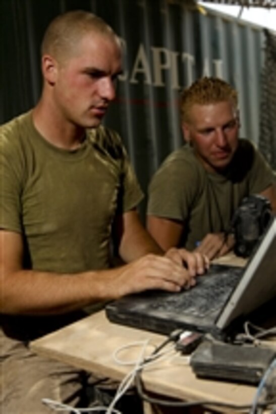U.S. Marine Corps Lance Cpl. Phillip Elgie (left) teaches Cpl. Kory Christenson video editing at the company's forward operating base in the Nawa district of Helmand province, Afghanistan, on Aug. 5, 2009.  Both Marines are with Alpha Company, 1st Battalion, 5th Marine Regiment.  Marines with 1st Battalion, 5th Marine Regiment, Regimental Combat Team 3, 2nd Marine Expeditionary Brigade–Afghanistan are deployed in support of NATO's International Security Assistance Force and will participate in counter insurgency operations and the training and mentoring of Afghan security forces.  