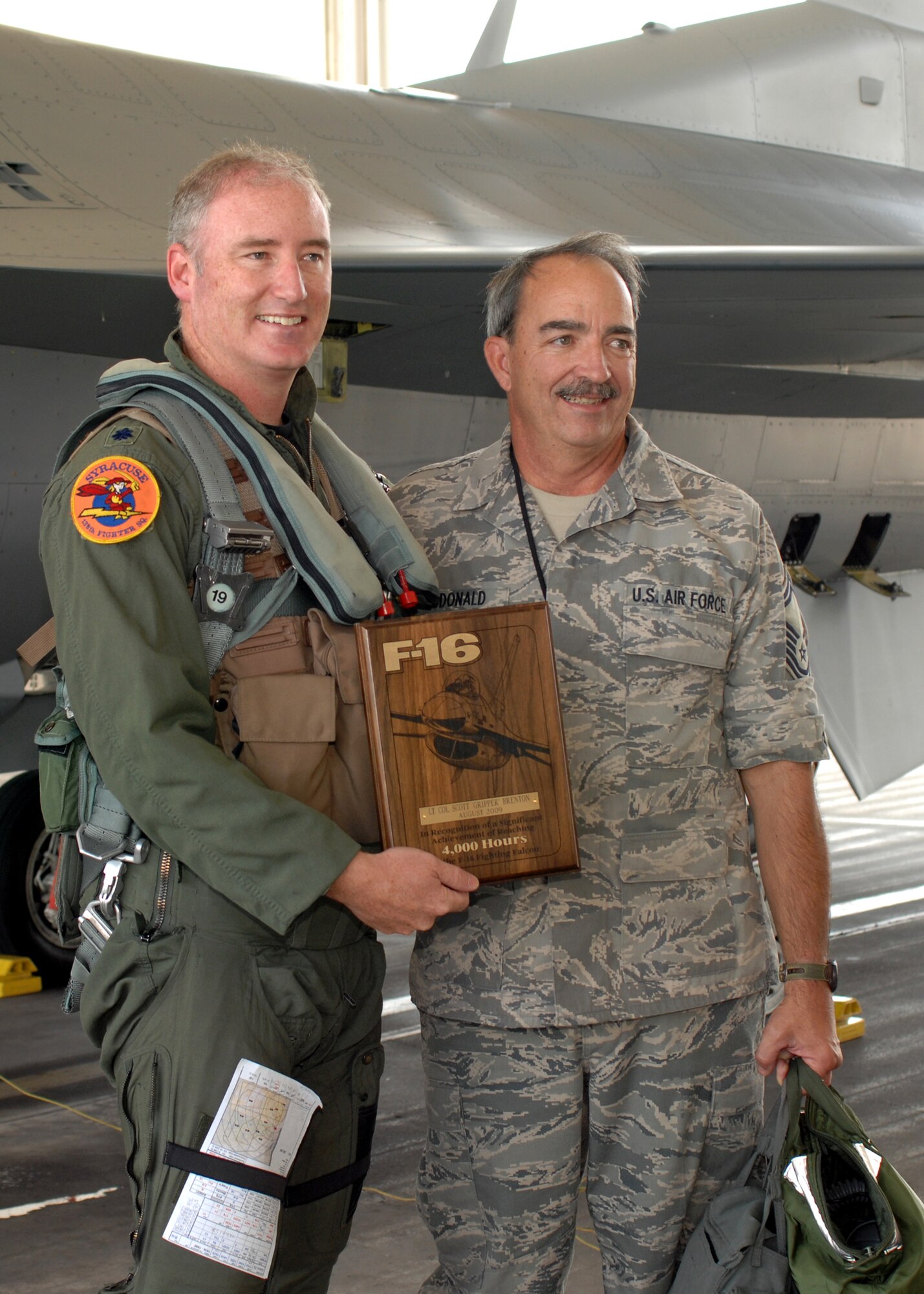 Lt. Col. D. Scott Brenton a pilot assigned to the 174th Fighter Wing, Hancock Field, Syracuse, NY posses with Senior Master Sgt. Christopher McDonald a crew chief commemorating Lt. Col. Brenton’s achievement of flying more then 4,000 hours inside the cockpit of the F-16 Fighting Falcon.