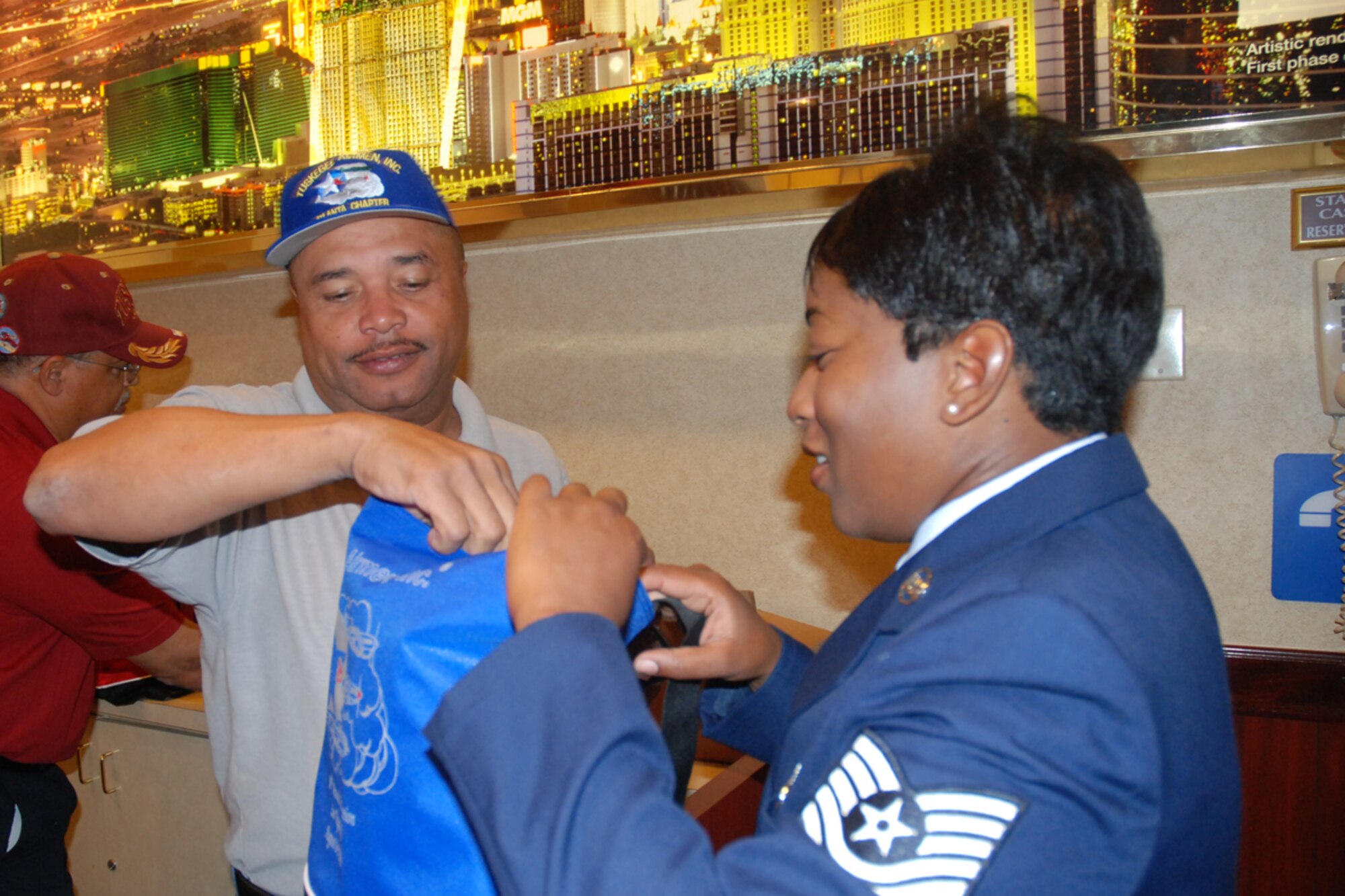 Master Sgt. Floyd Stanfield, AGE flight chief, 94th Maintenance and president of the Tuskegee Airman, Inc. Atlanta Chapter, checks in Tech. Sgt. Deborah McLean, chief of personnel relocations, 94th Mission Support Squadron and TAI Atlanta Chapter member at the 38th Annual TAI National Convention, Palace Station Hotel, Las Vegas NV. Aug 6. (U.S. Air Force photo/Tech. Sgt. James Branch)