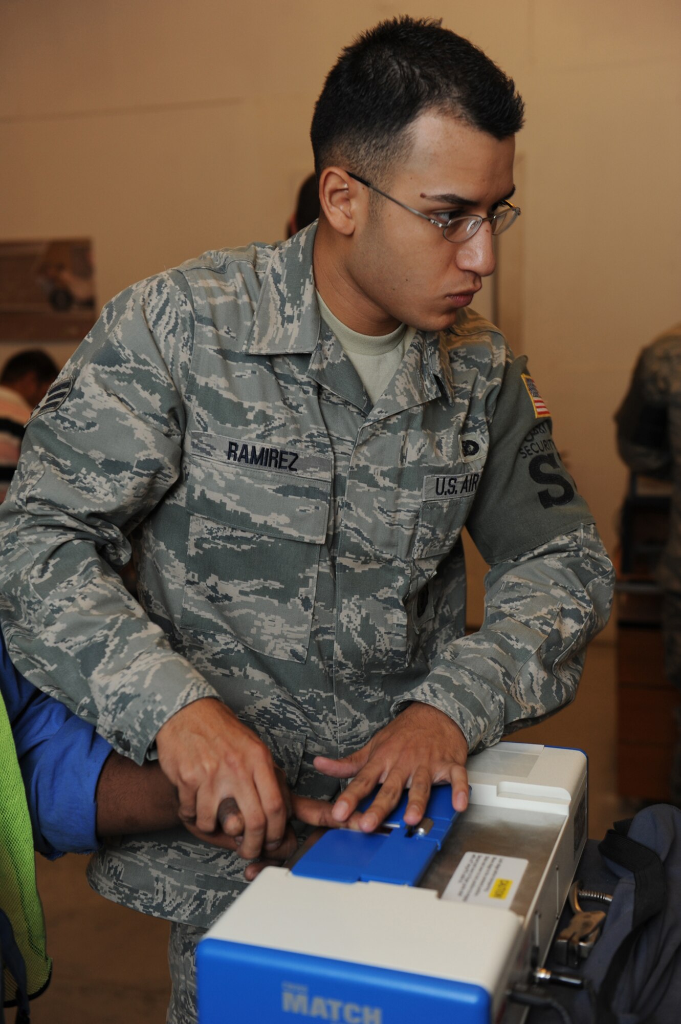 Senior Airman Juan Ramirez, 379th Expeditionary Security Forces Squadron DBIDS registrar, processes a third country national into the Defense Biometrics Identification System in Southwest Asia. DBIDS is an enhanced security system used to monitor entry onto military installations. A native of Laredo, Texas, Airman Ramirez is deployed from Maxwell Air Force Base, Ala. in support of Operations Iraqi and Enduring Freedom. (US Air Force Photo/Staff Sgt. Robert Barney)