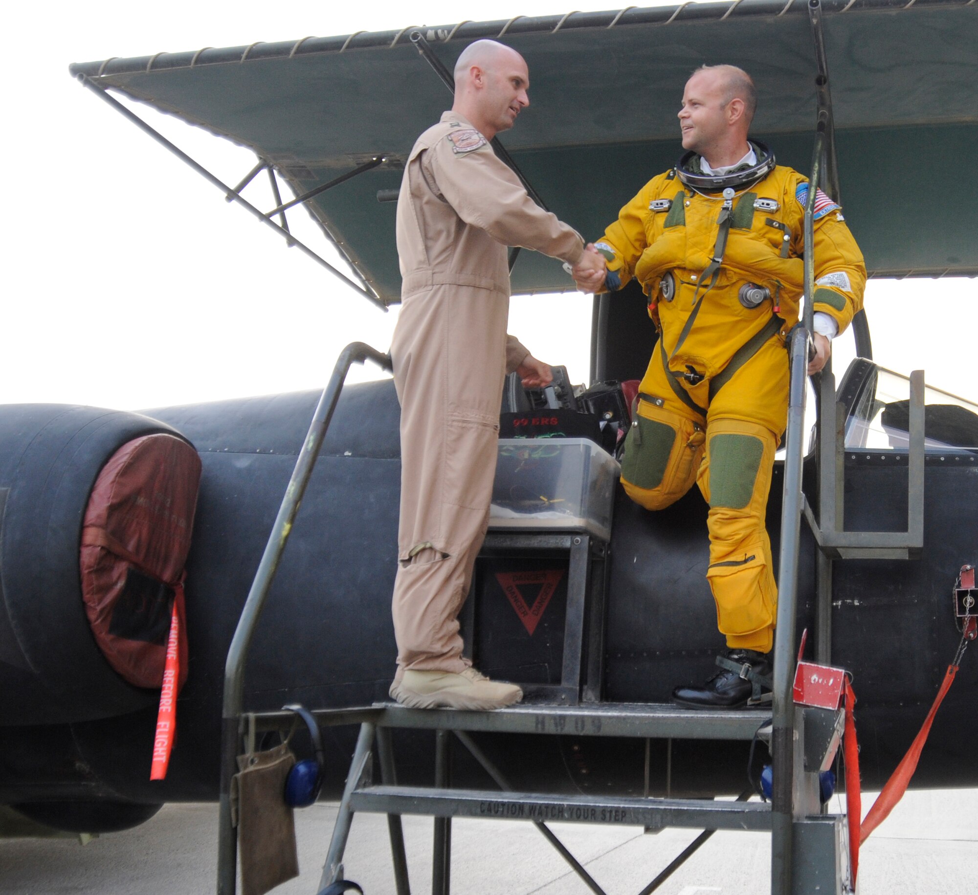 Maj. Ross Franqemont, 99th Expeditionary Reconnaissance Squadron, steps out of a U-2 and is congratulated for flying more than 1,000 hours in the U-2 by Capt. Jon Brown, 380th Air Expeditionary Wing Safety Office, Aug. 6. Major Franqemont is 236th person in 54 years to pass 1,000 hours in the U-2. Major Franqemont and Captain Brown are both deployed from Beale AFB, Calif. Major Franqemont hails from Lenoir, N.C., and Captain Brown hails from Hattiesburg, Miss.(U.S. Air Force photo/Senior Airman Stephen Linch) 