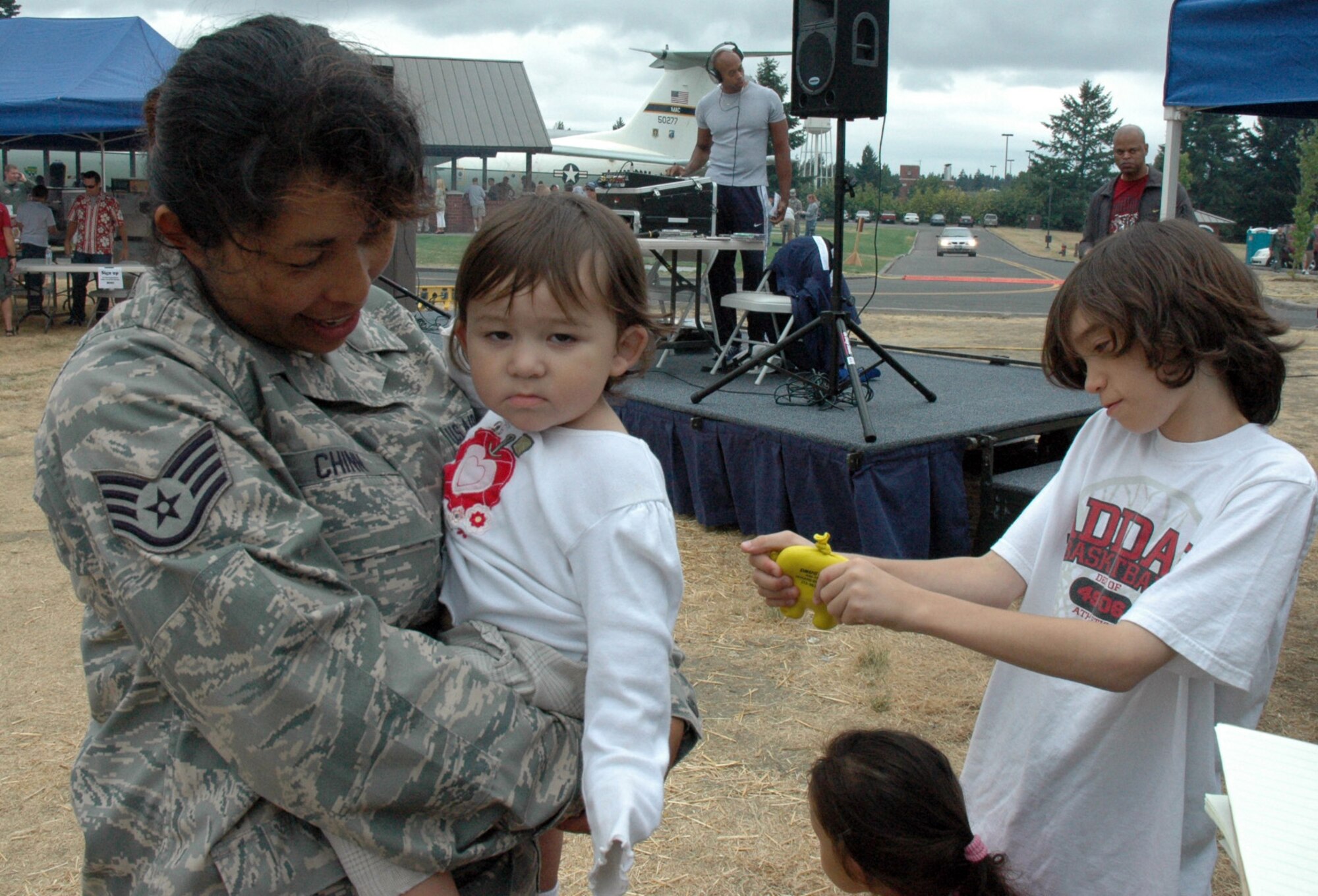 Staff Sgt. Anayansi Chinn, 446th Mission Support Squadron, holds her 13-month-old daughter Samantha, while son Jarrett, 11, and daughter, Hope, 3, enjoy themselves at the 446th Airlift Wing annual Family Day celebration on Aug. 8, at Heritage Hill, McChord Air Force Base, Wash. (U.S. Air Force photo/Tech Sgt. Jake Chappelle). 