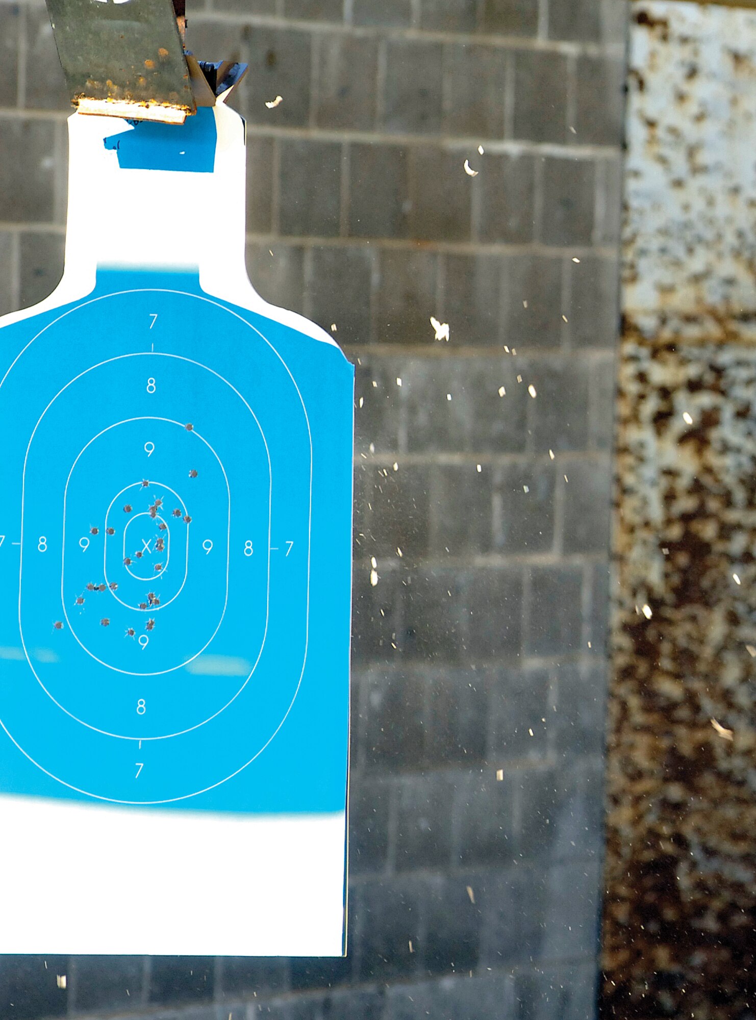 Cardboard explodes from the back of targets downrange as rounds hit the mark during the 12th annual AFOSI-sponsored pistol competition July 31.