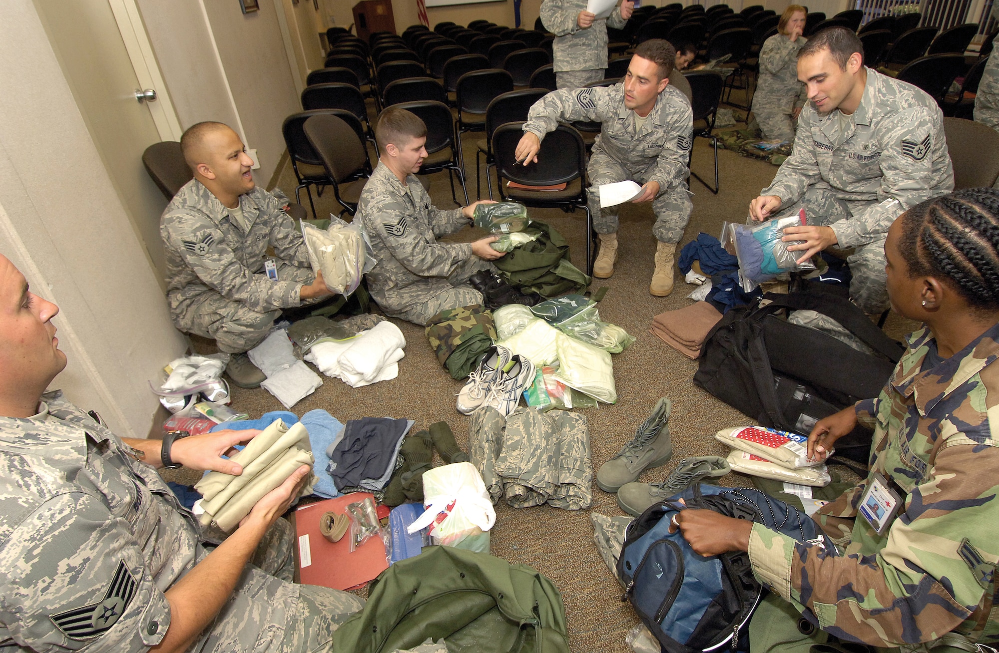 Air Force photo by Margo Wright During an exercise last week, 72nd Medical Group Airmen haul  out their personal gear as called for by exercise evaluator Tech. Sgt. Duane Roe, center. Ensuring deployment requirements are met in such exercises prepares Airmen for actual deployments and the Operational Readiness Inspection this fall.
